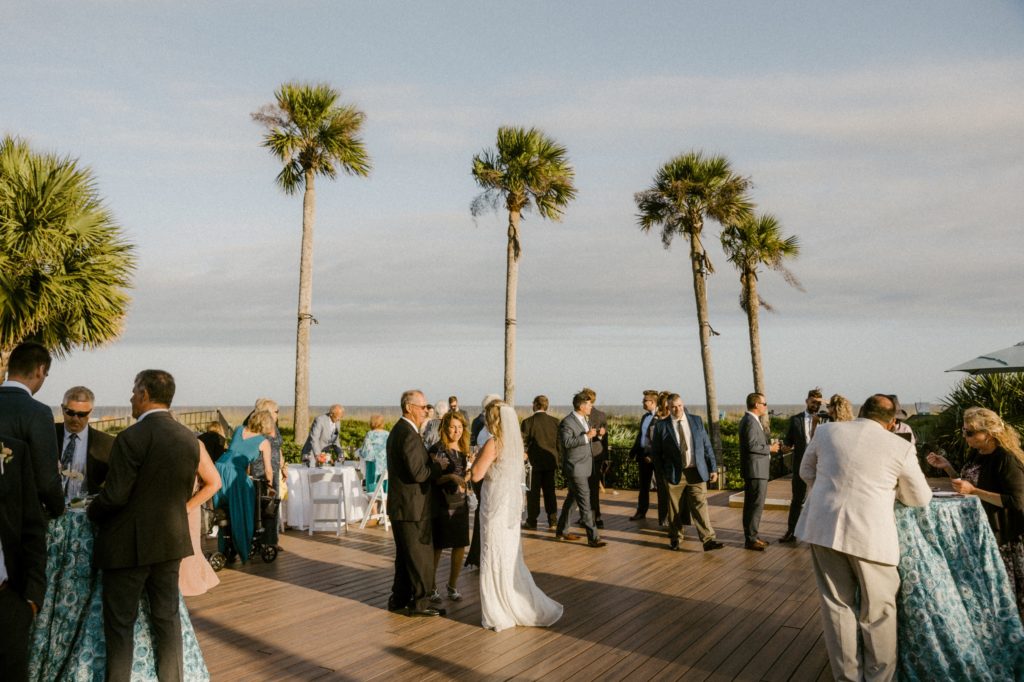 bride talks to guest at cocktail hour for hilton head beach wedding 