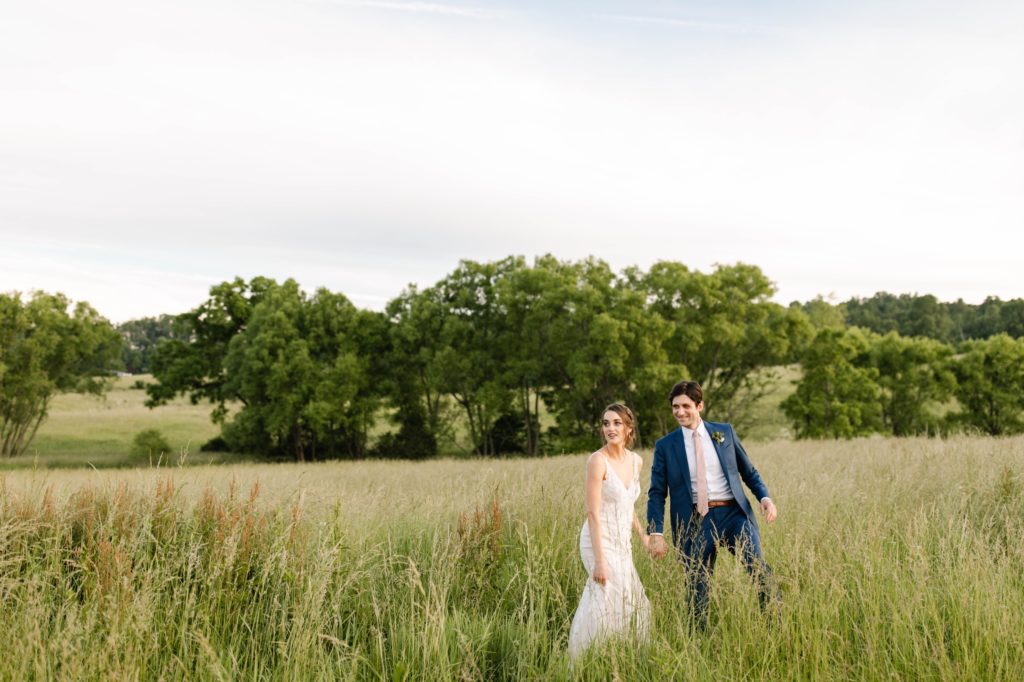 couple walking romantically through field