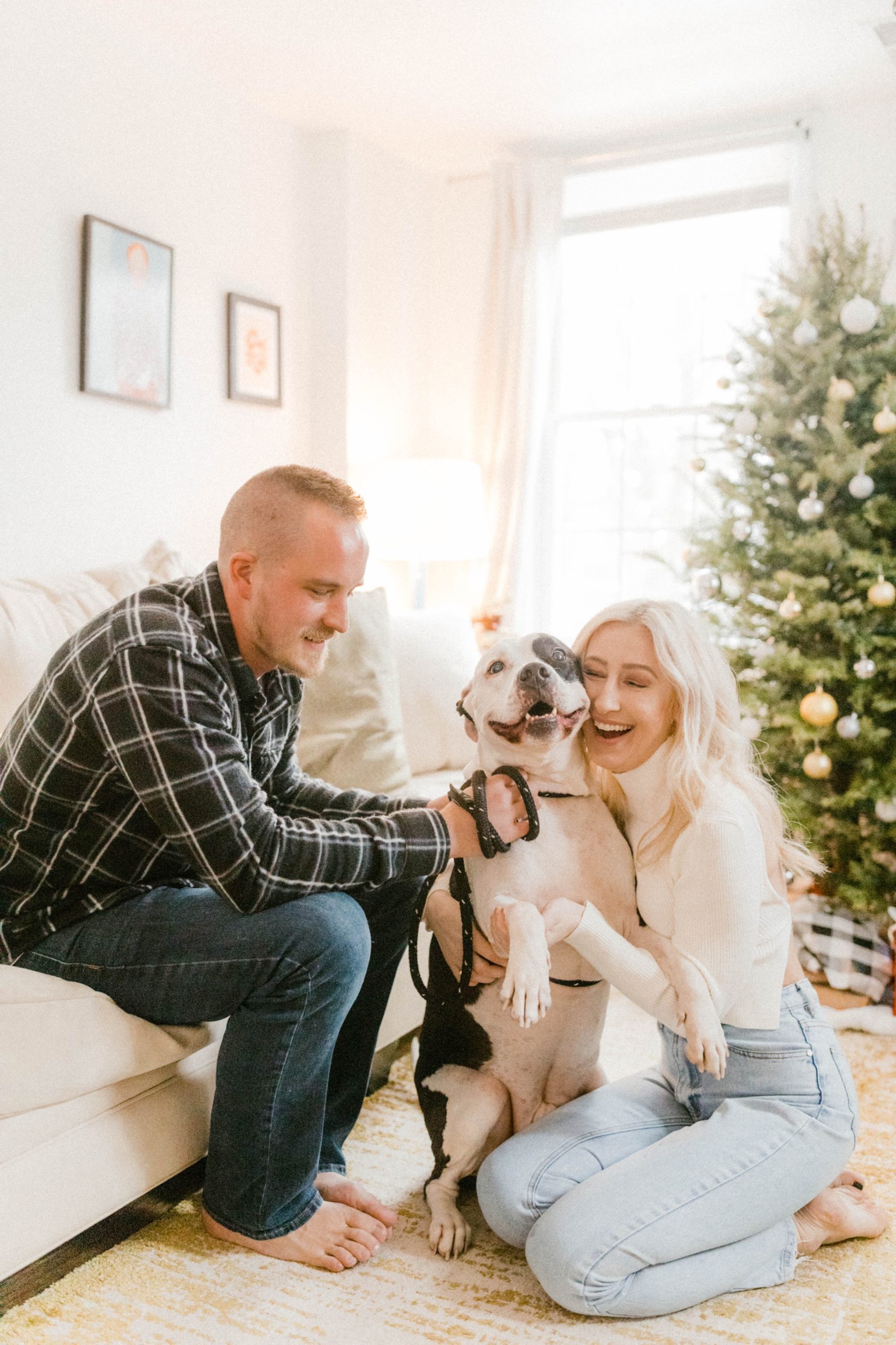 a couple hugging their dog for in home engagement session