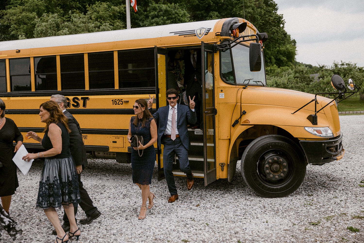 guests arriving to wedding school bus