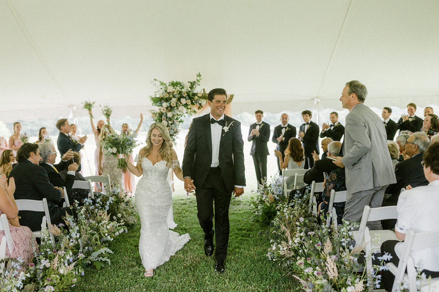 bride groom walking out of wedding ceremony tent