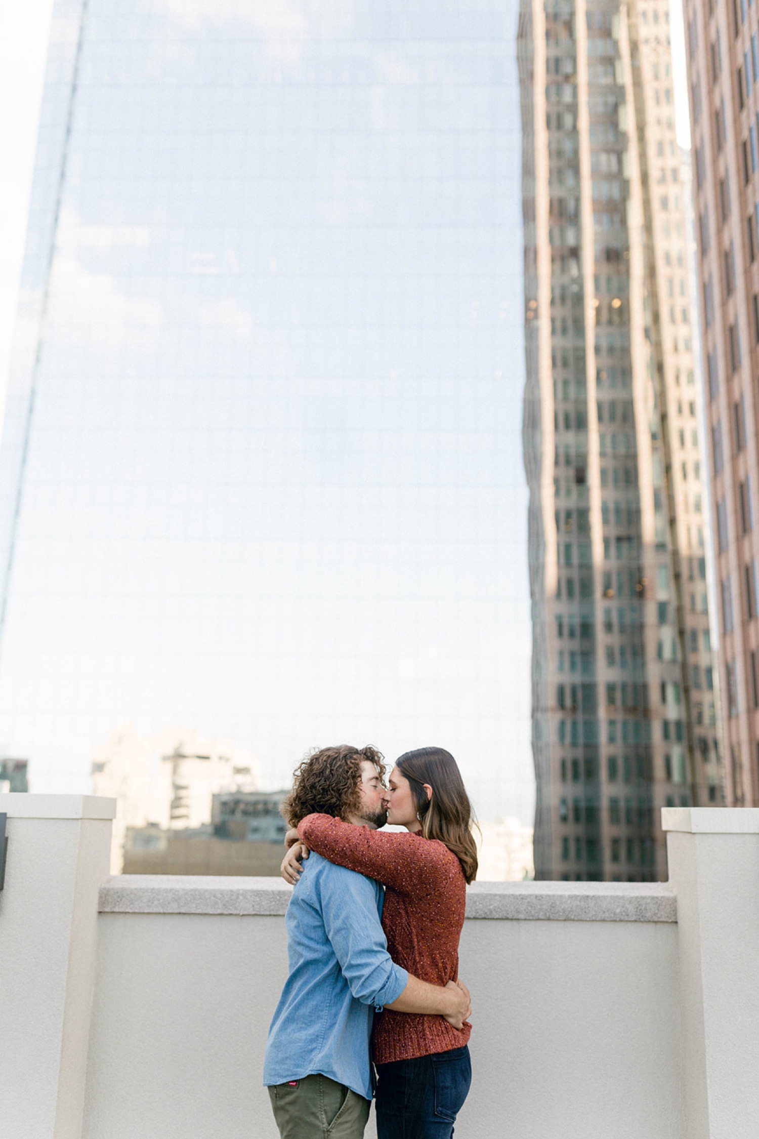 couple kissing in front of glass building