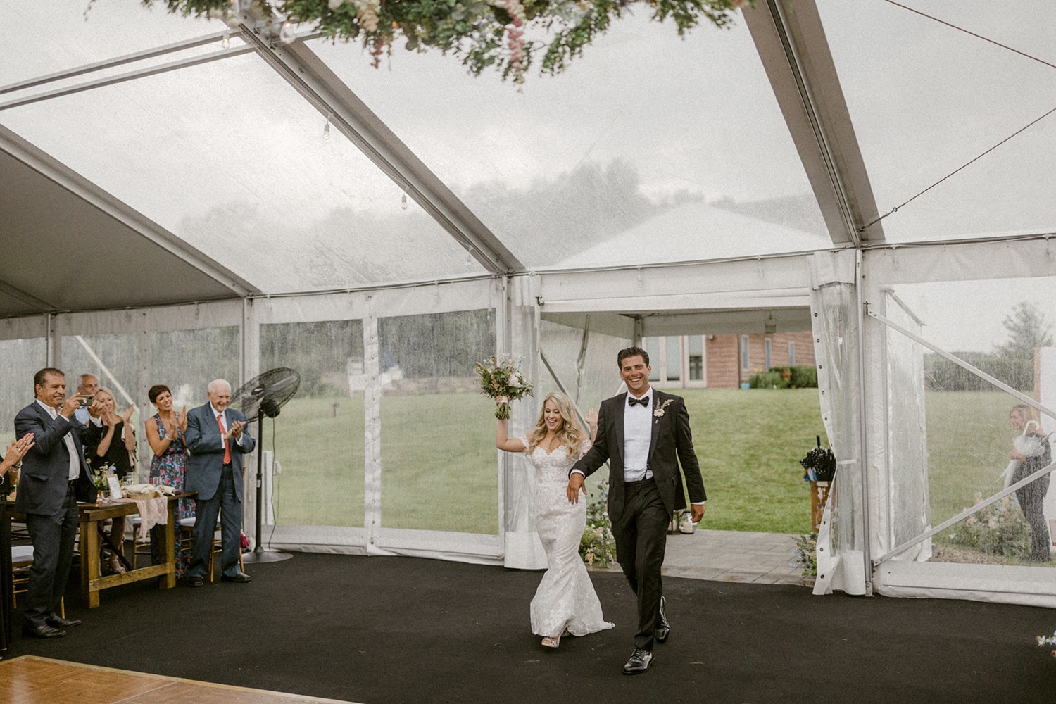 bride and groom entering tent wedding reception