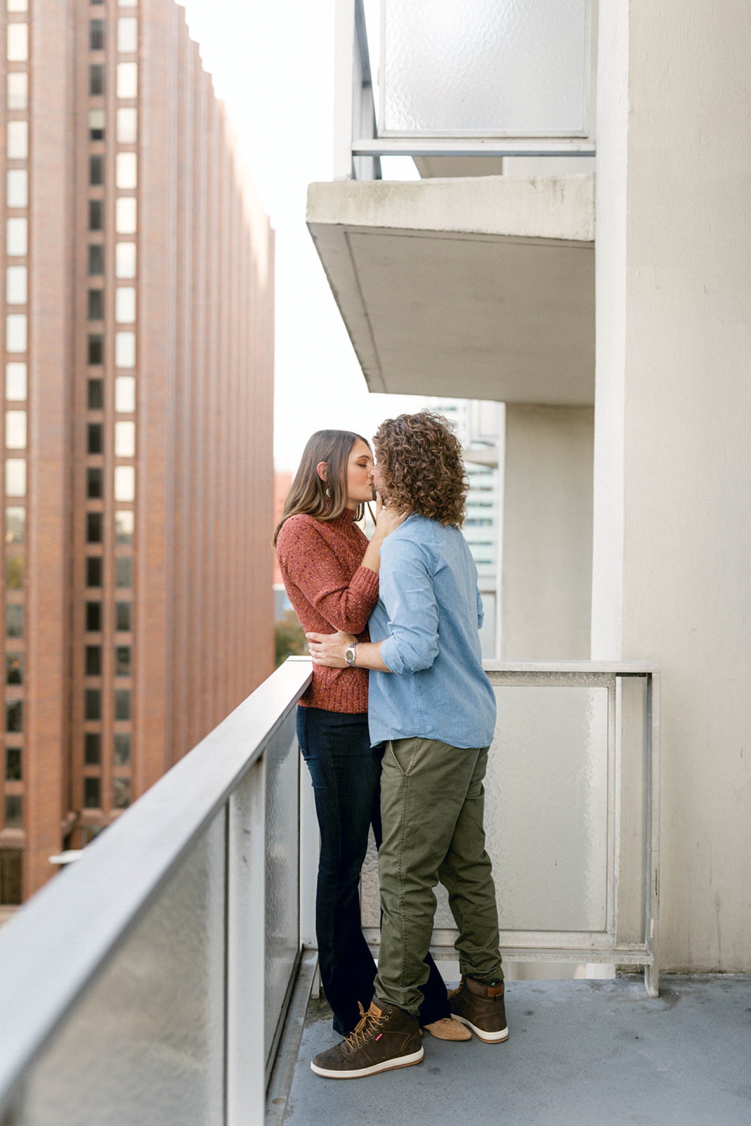couple kissing outside on balcony in city