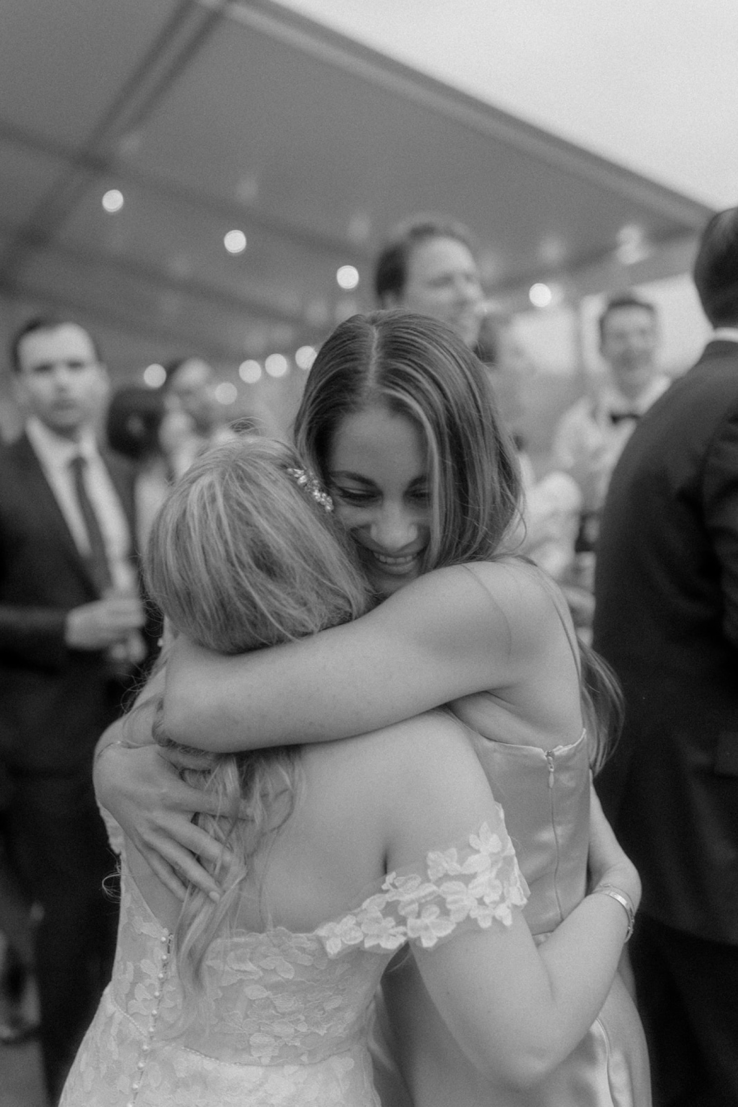bride and sister hugging at wedding reception
