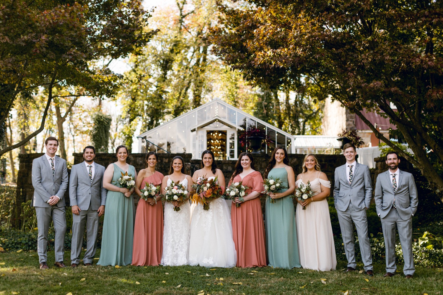 wedding party in front of greenhouse