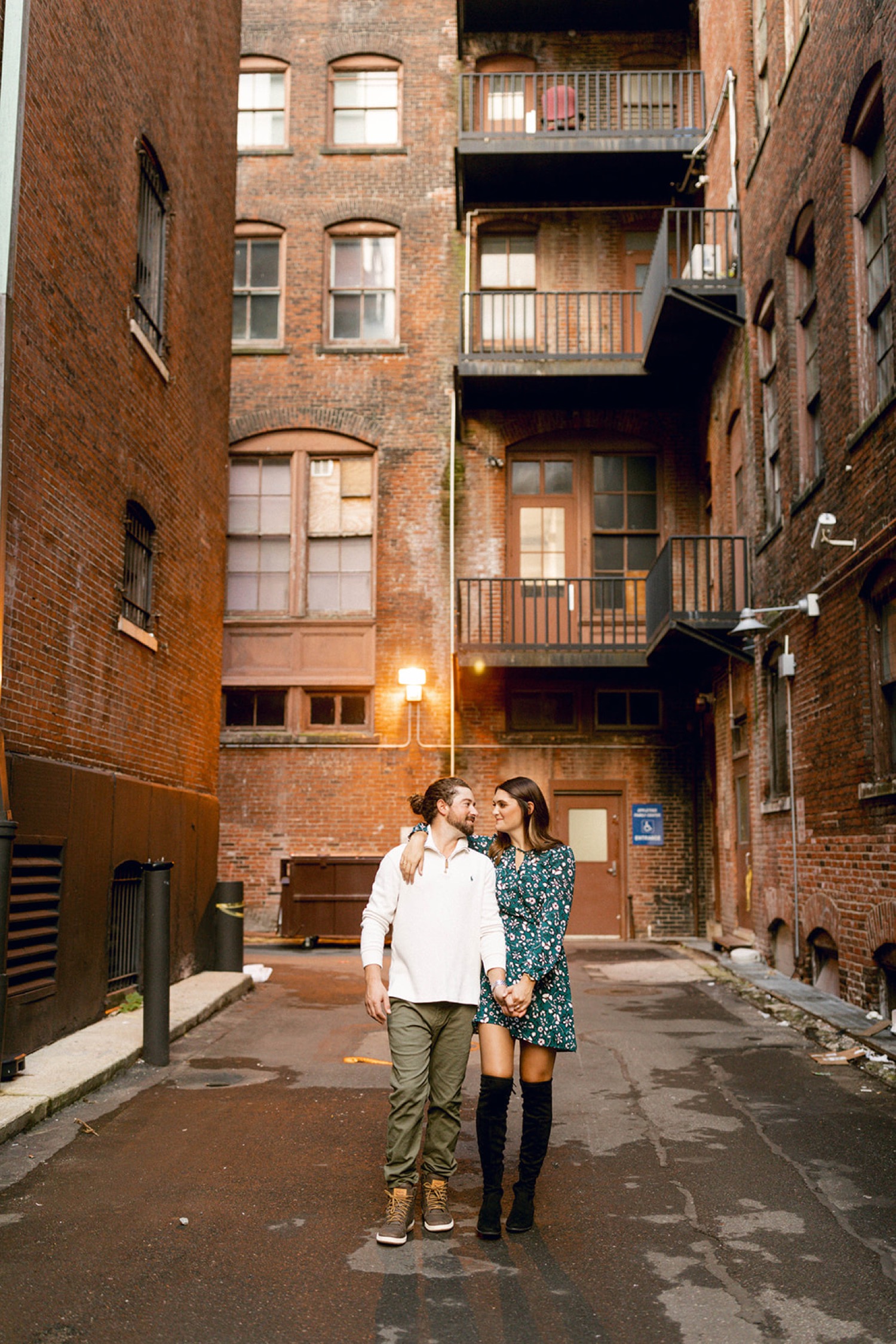 couple walking surrounded by brick buildings