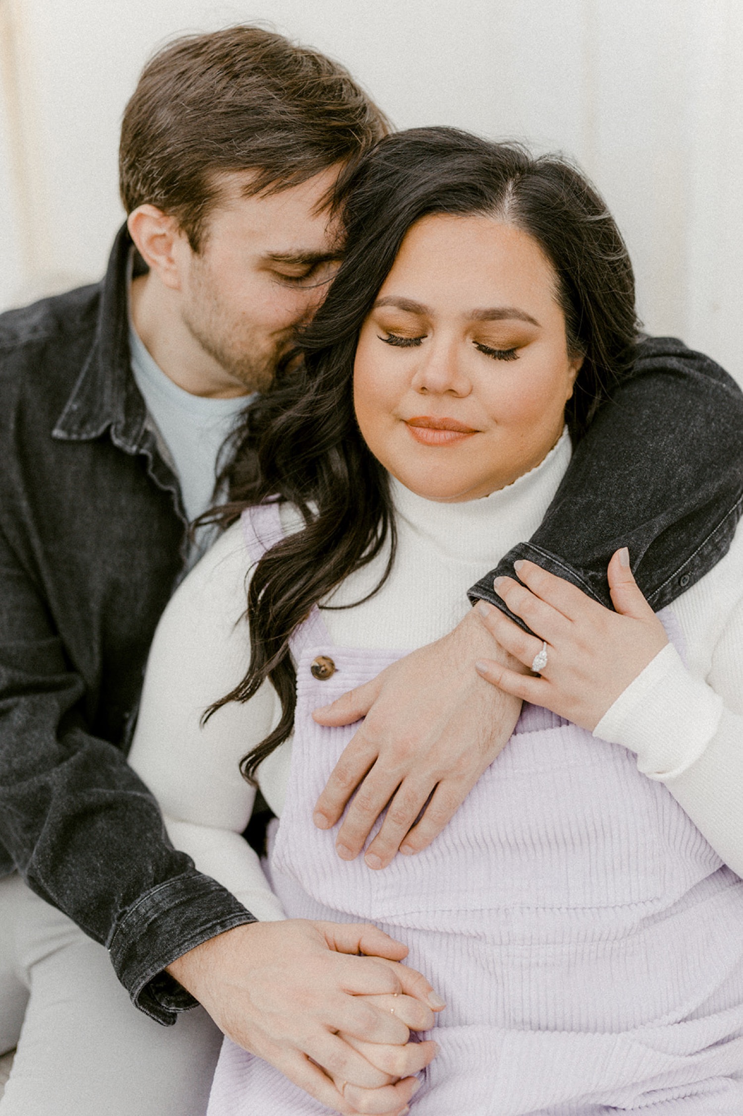 couple engagement session eyes closed embracing