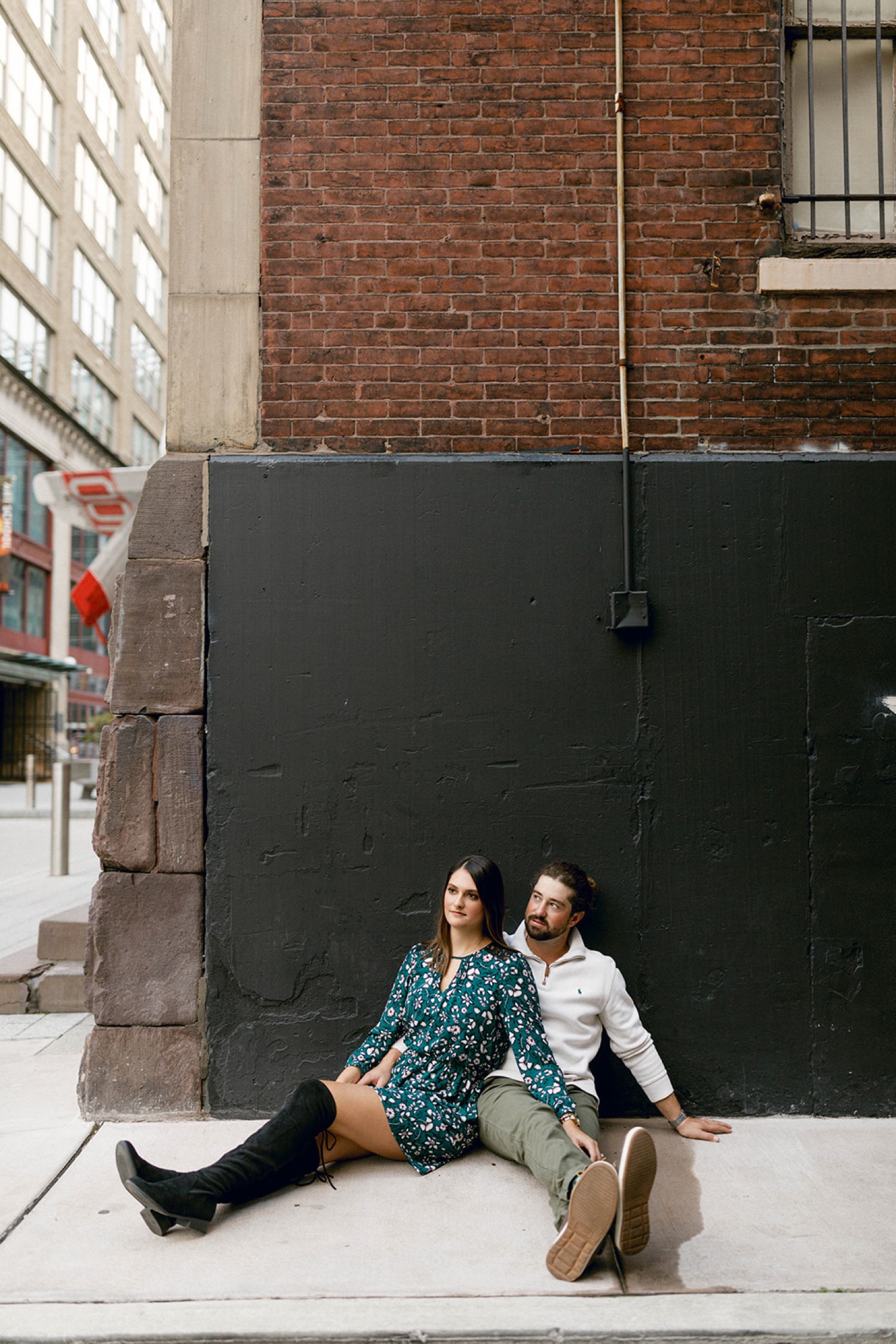 couple sitting in front of brick building