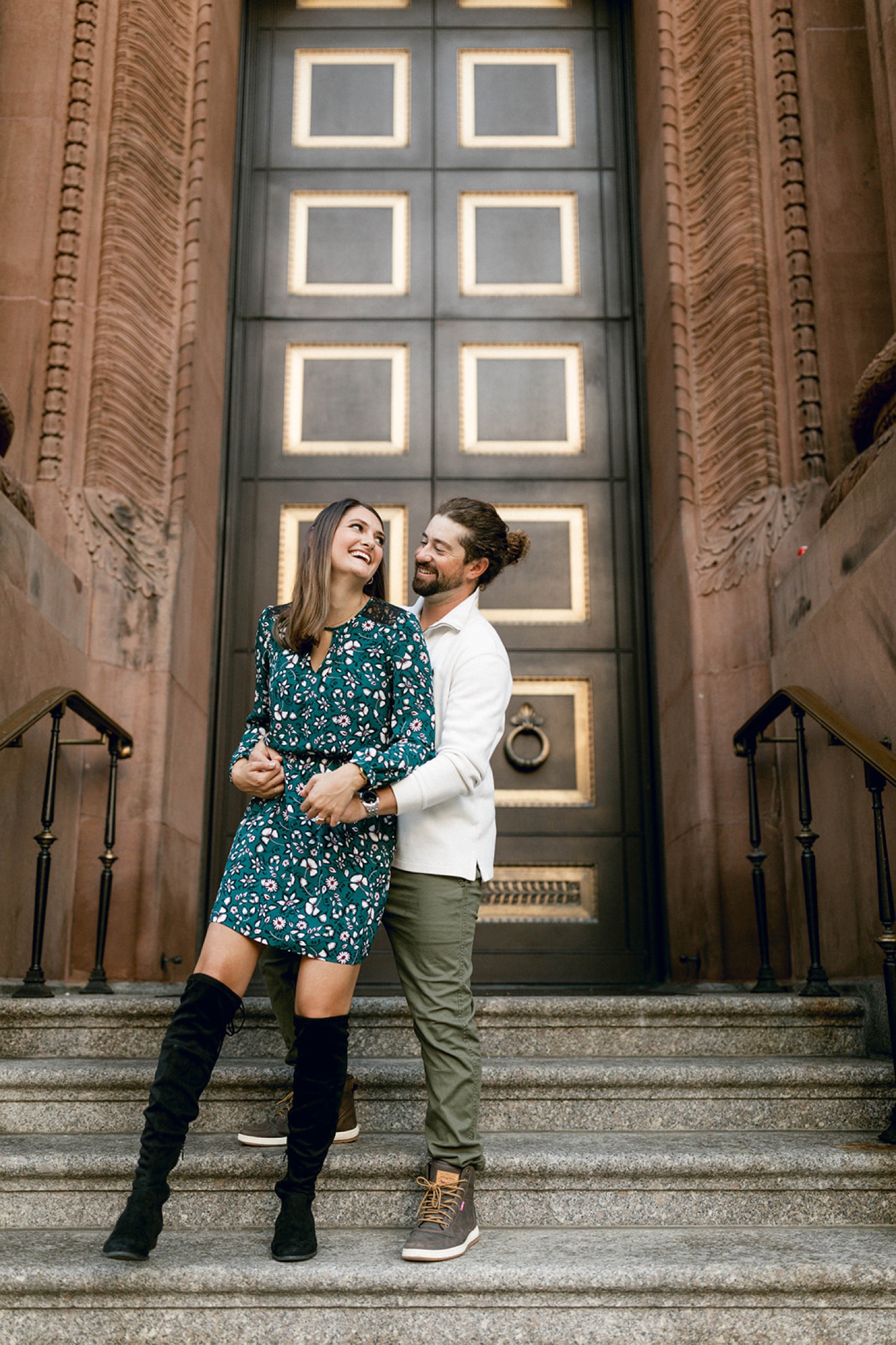 couple laughing on steps in front of historical building