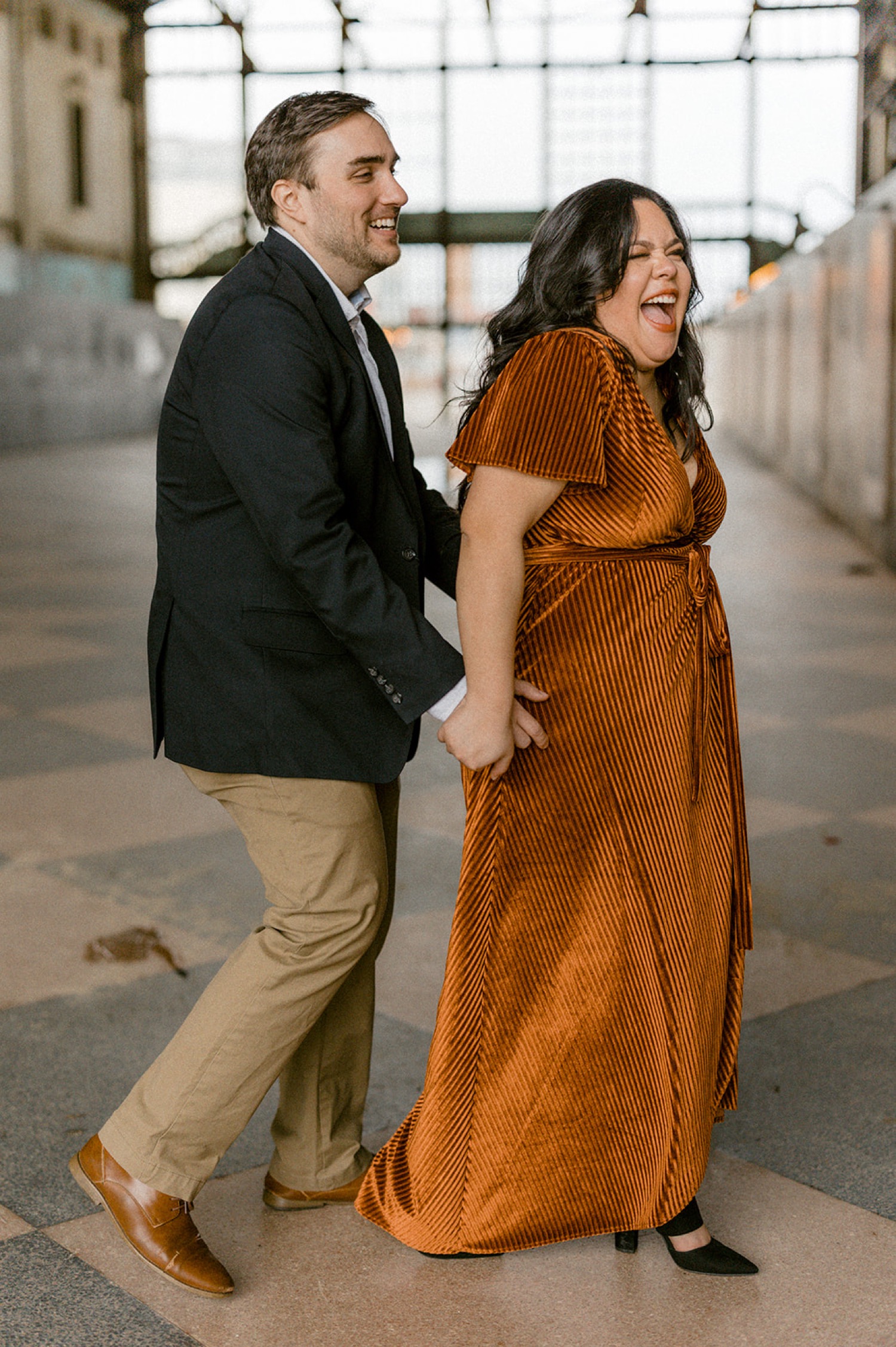 couple laughing formal attire engagement session in warehouse