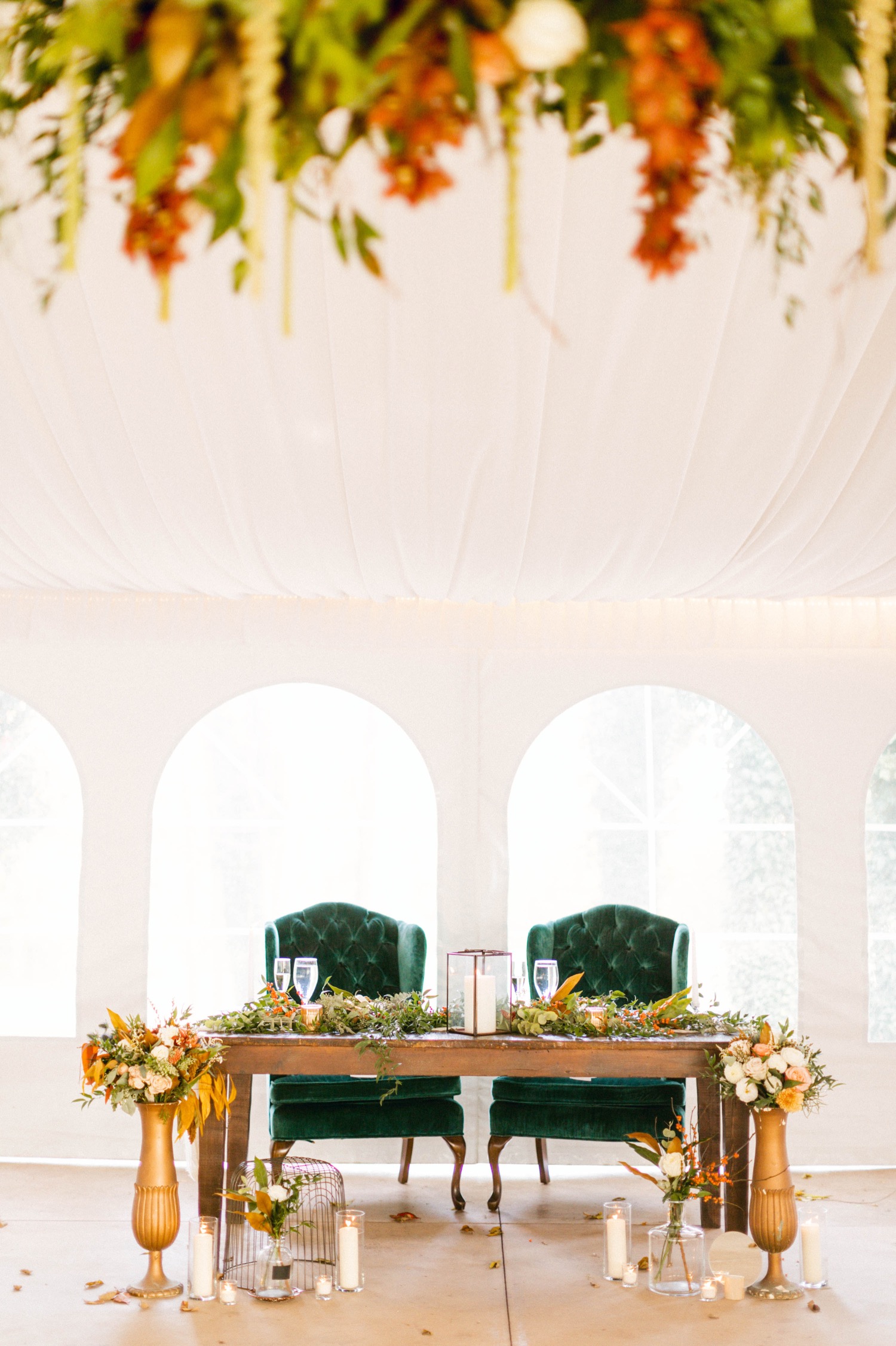 wedding head table with autumn flowers and teal chairs and hanging wreath