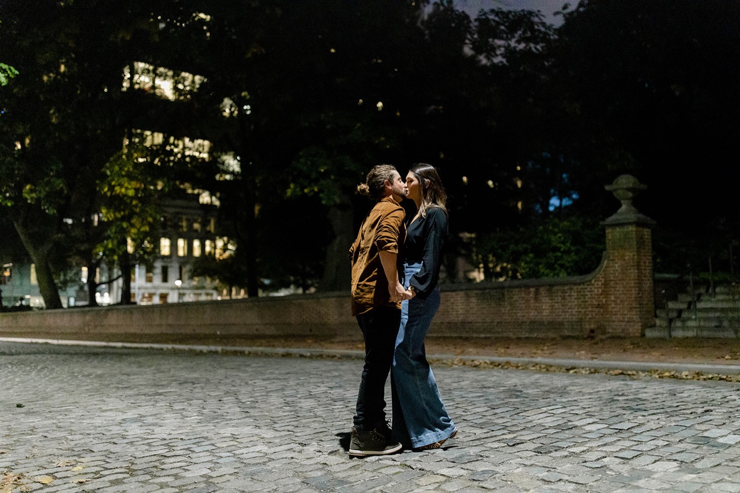couple kissing on cobblestone street