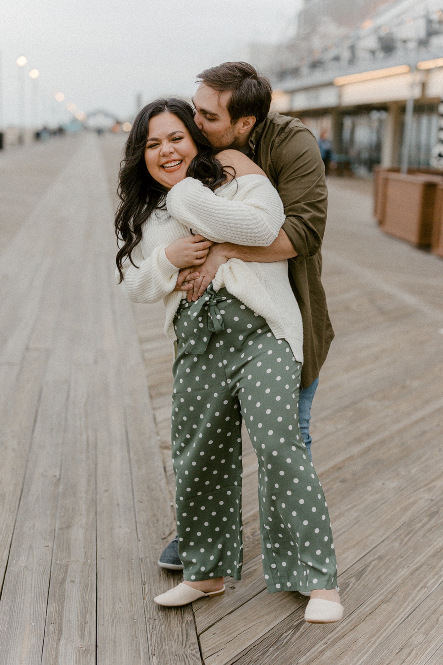 couple laughing swaying embrace on boardwalk cozy