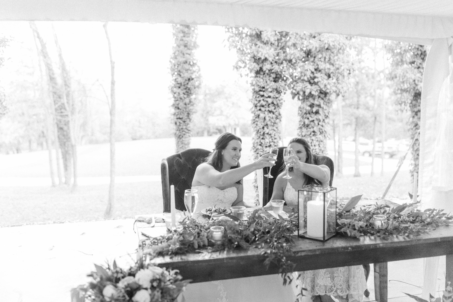 brides cheers at wedding head table