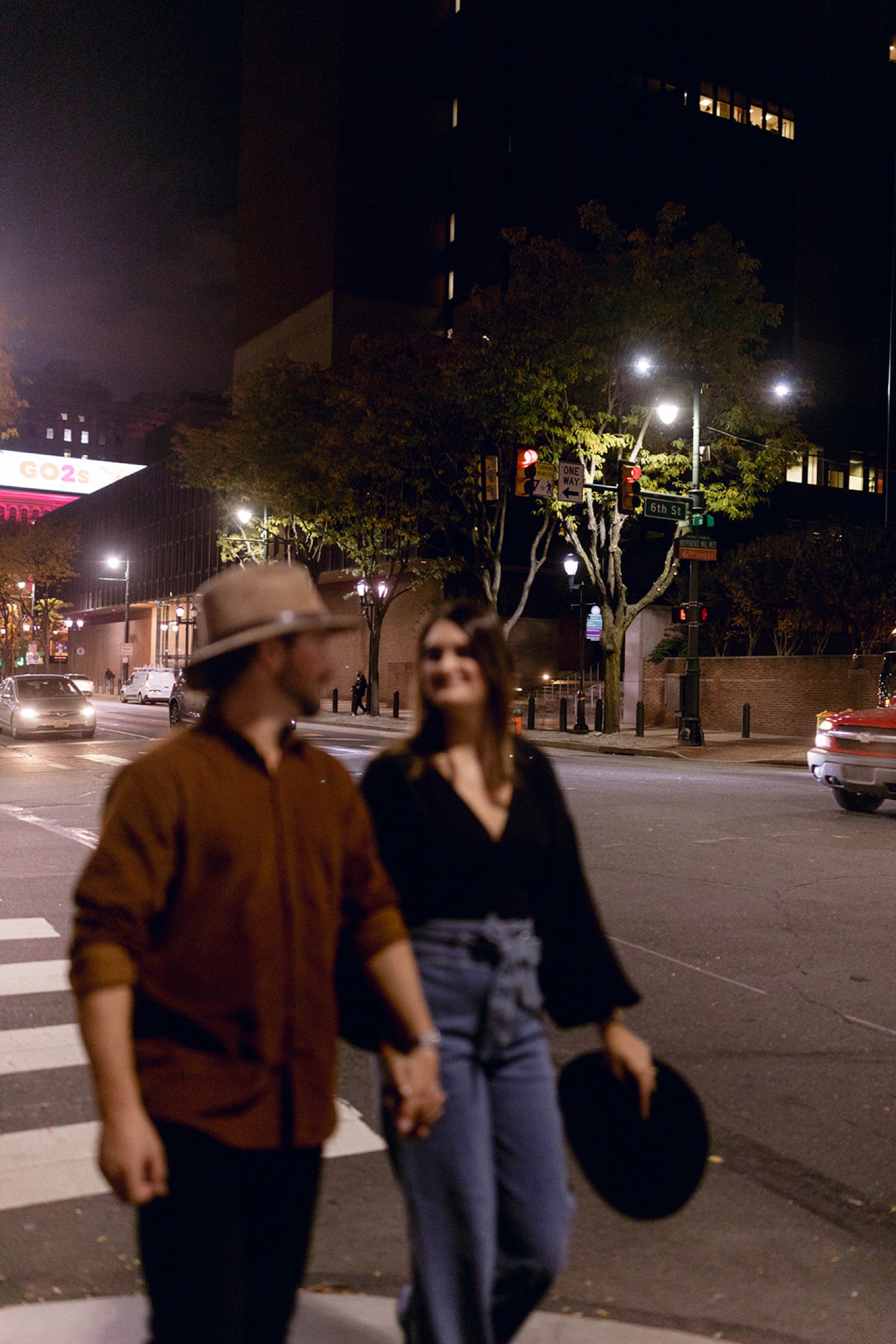 blurred couple with downtown shops at night