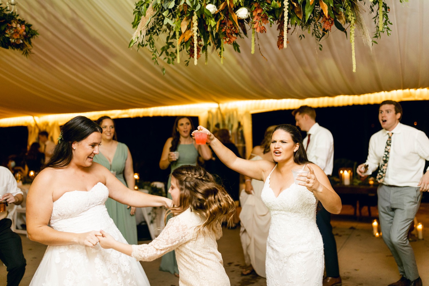 brides dancing with guests at wedding reception
