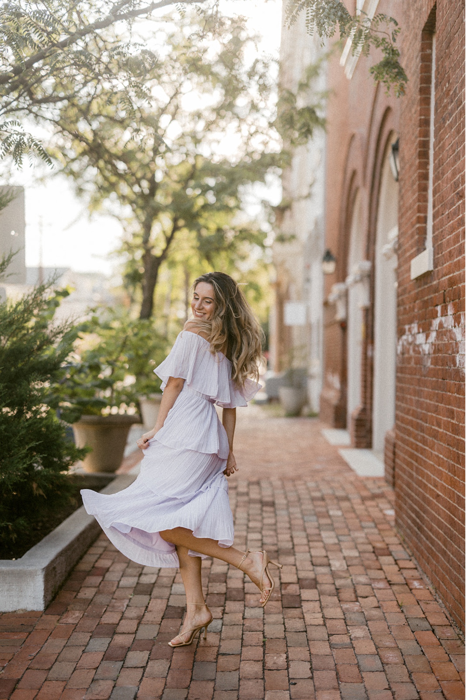 girl twirling in dress on brick sidewalks