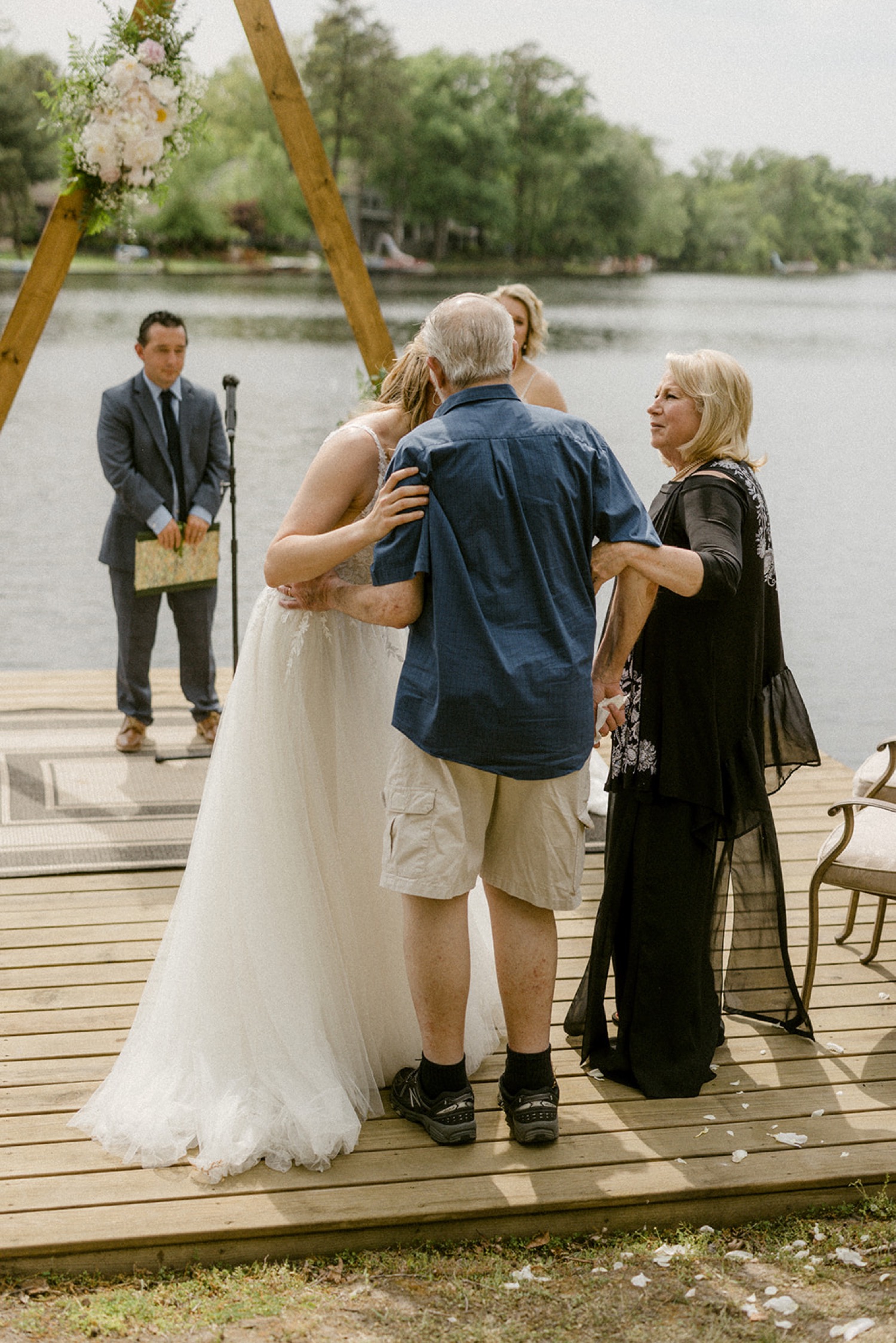 bride hugging parents on dock lakeside backyard micro wedding