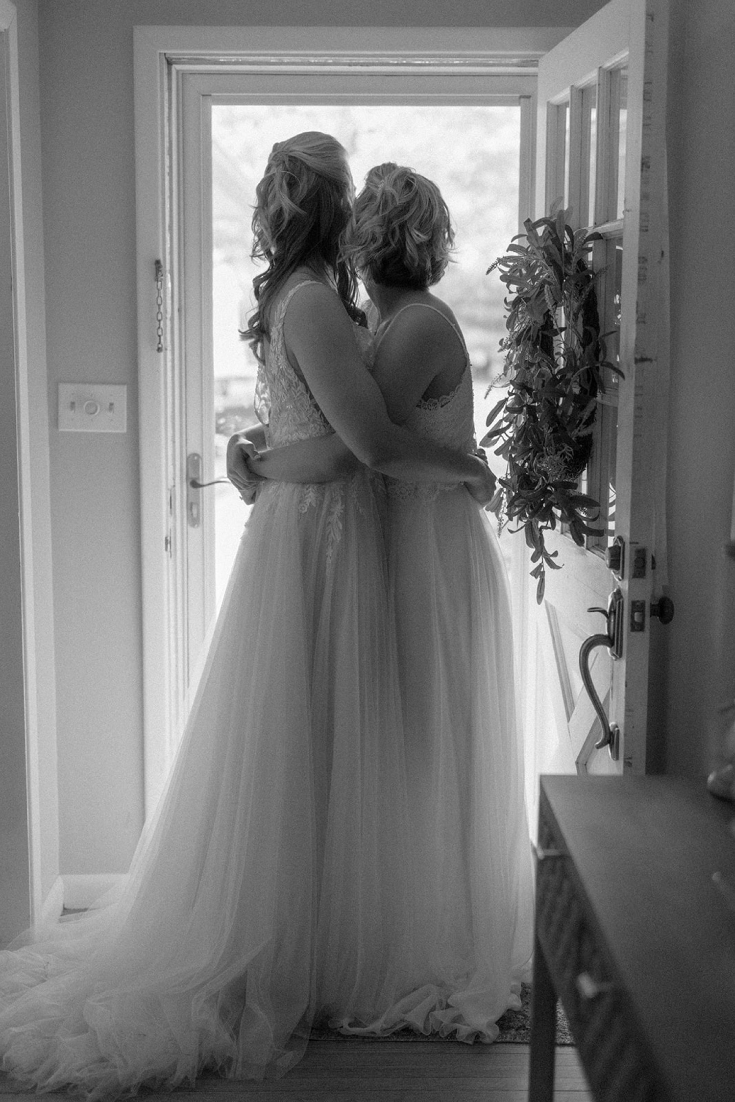 black and white brides hugging in door frame silhouette