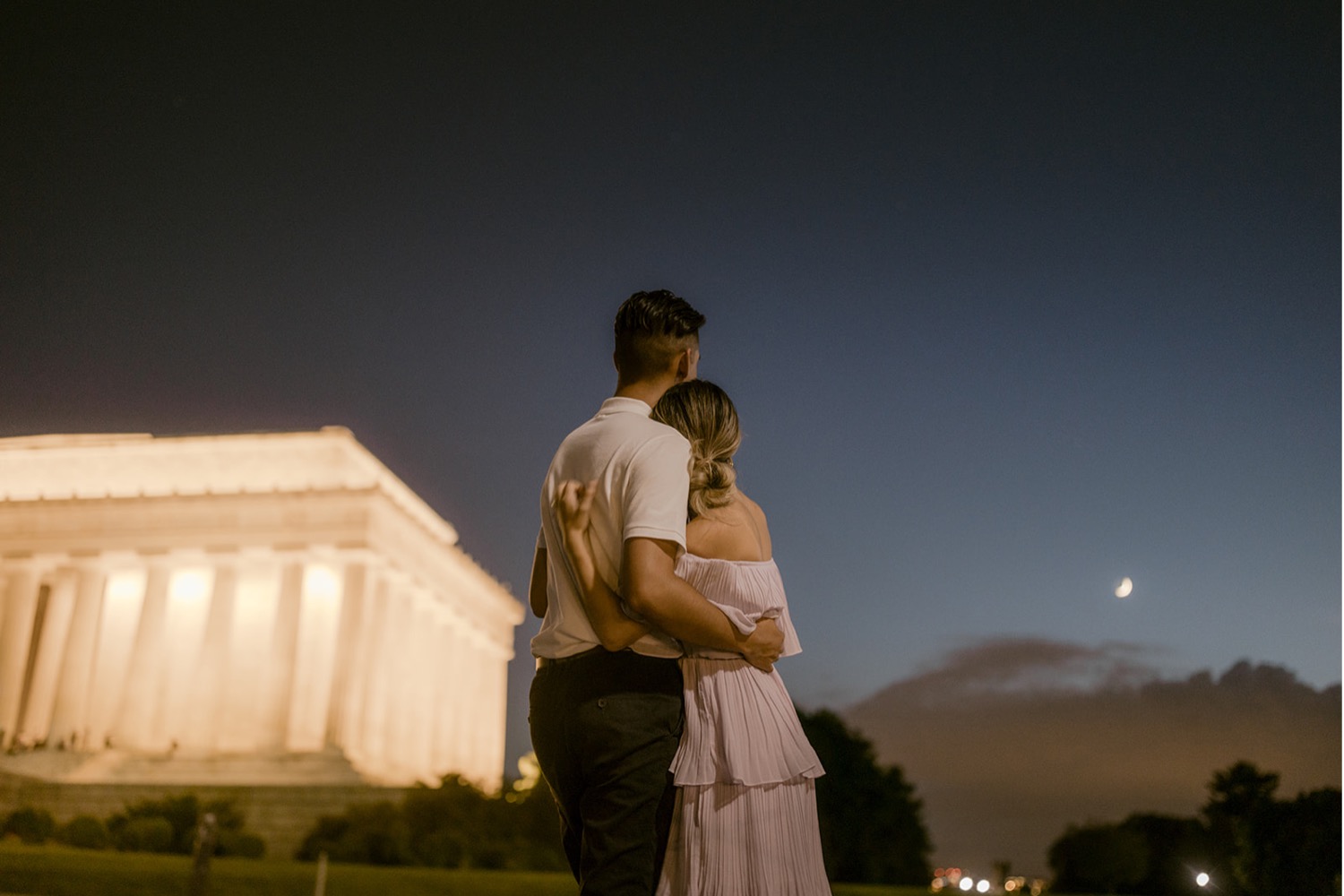 couple looking at moon and monument at night washington dc engagement session