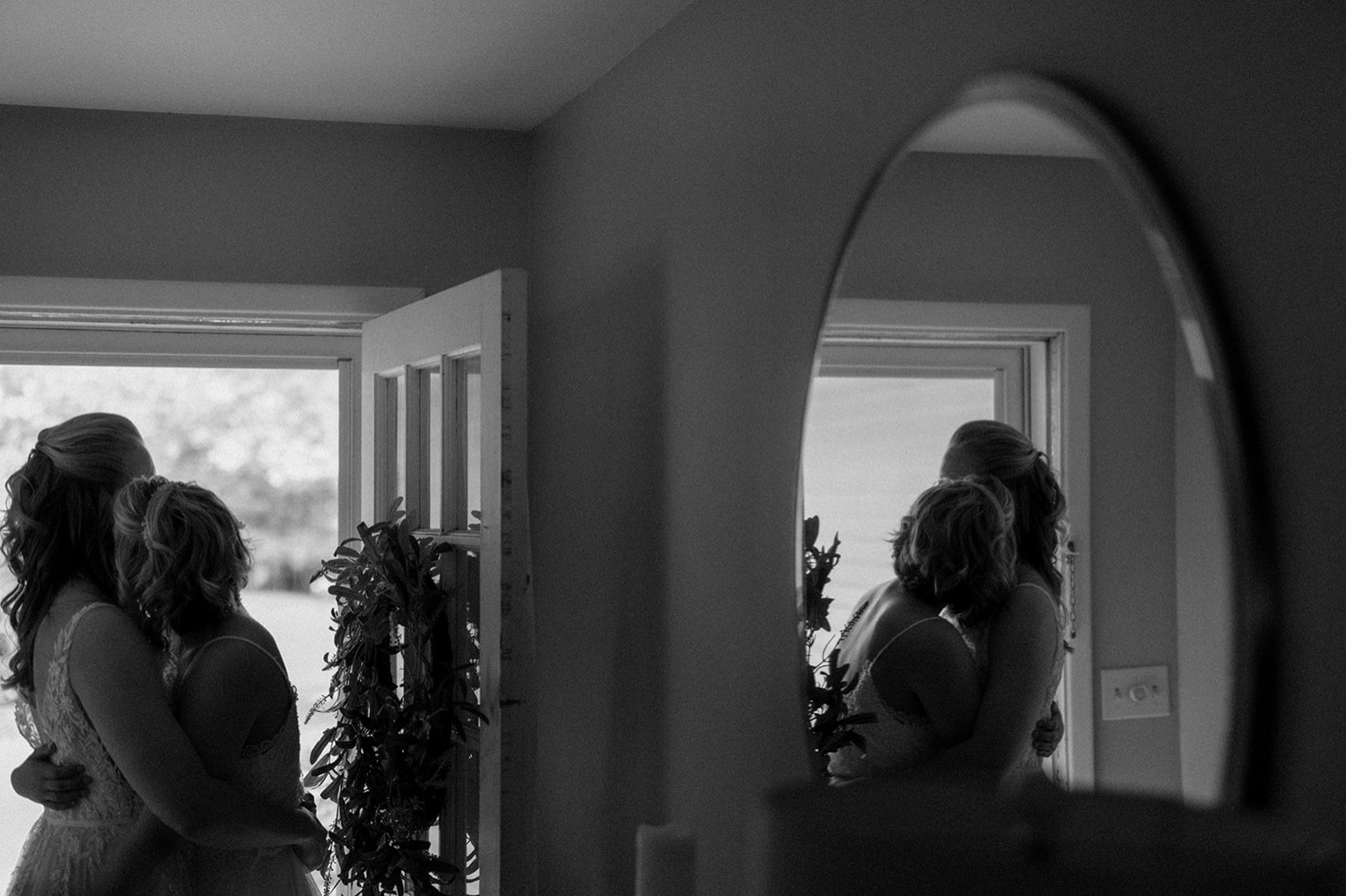 black and white brides hugging reflection in mirror