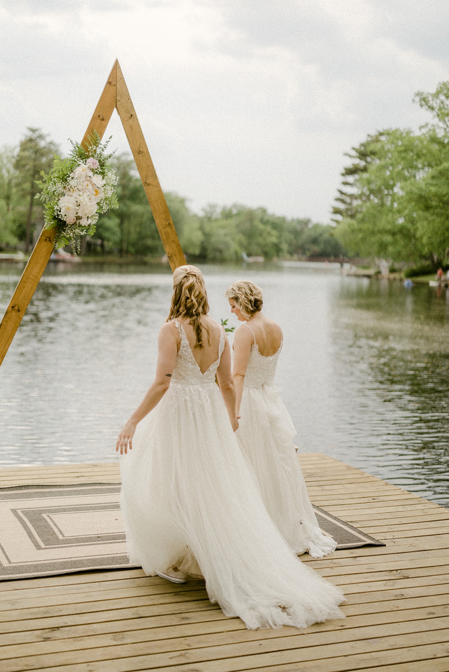 brides walking towards arbor for first dance lakeside backyard micro wedding
