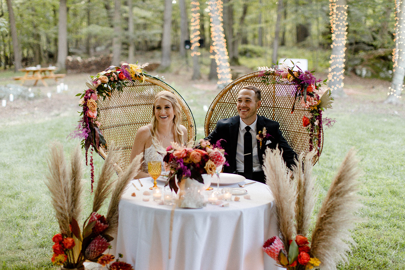 couple sitting at head table during reception colorful bohemian backyard micro wedding