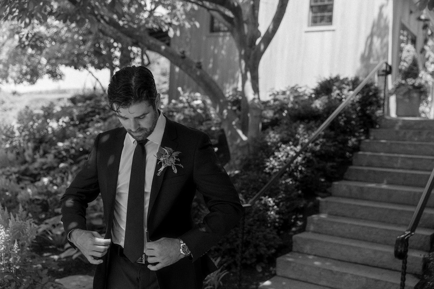 groom buttoning suit jacket wedding