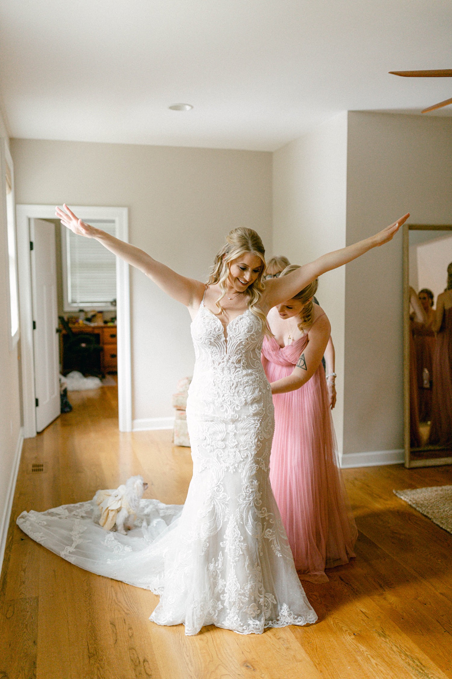 bride arms in the air buttoning wedding dress