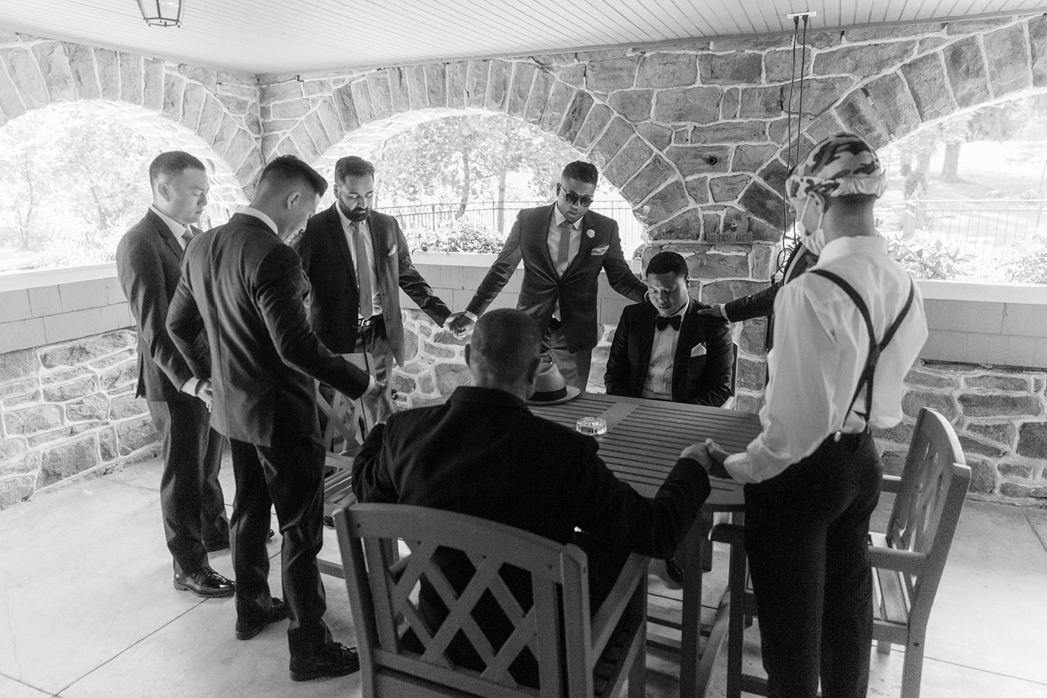 groom and groomsmen praying before wedding