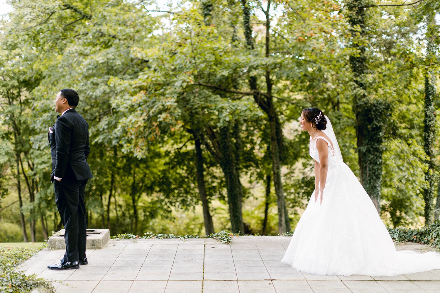 bride walking towards groom for first look in the woods