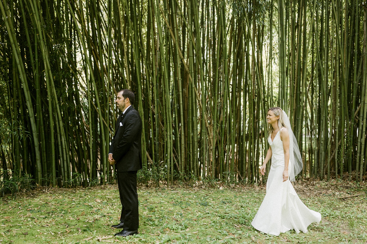 bride walking towards groom first look bamboo