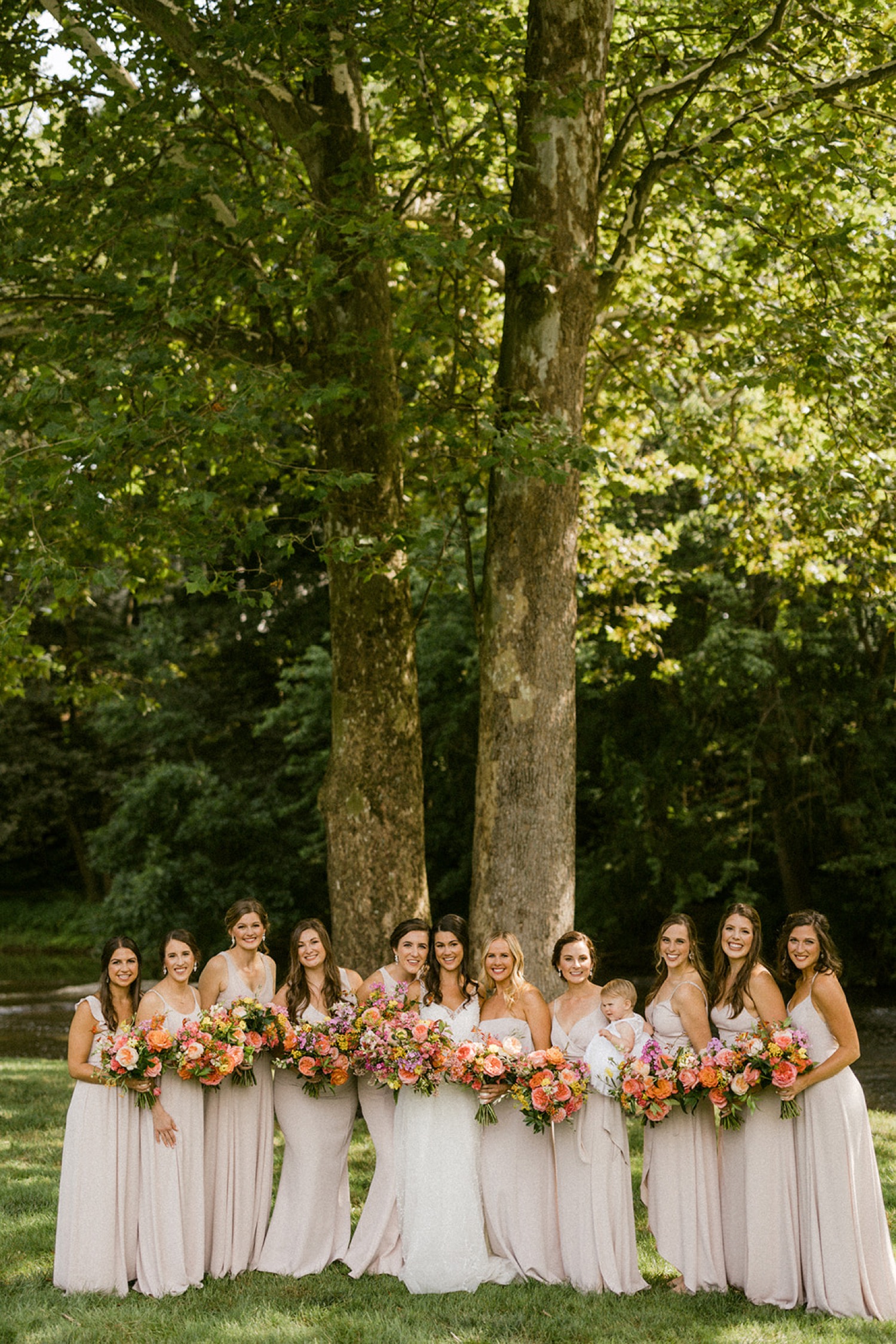 bridesmaids in pink dresses colorful flowers dreamy backyard wedding
