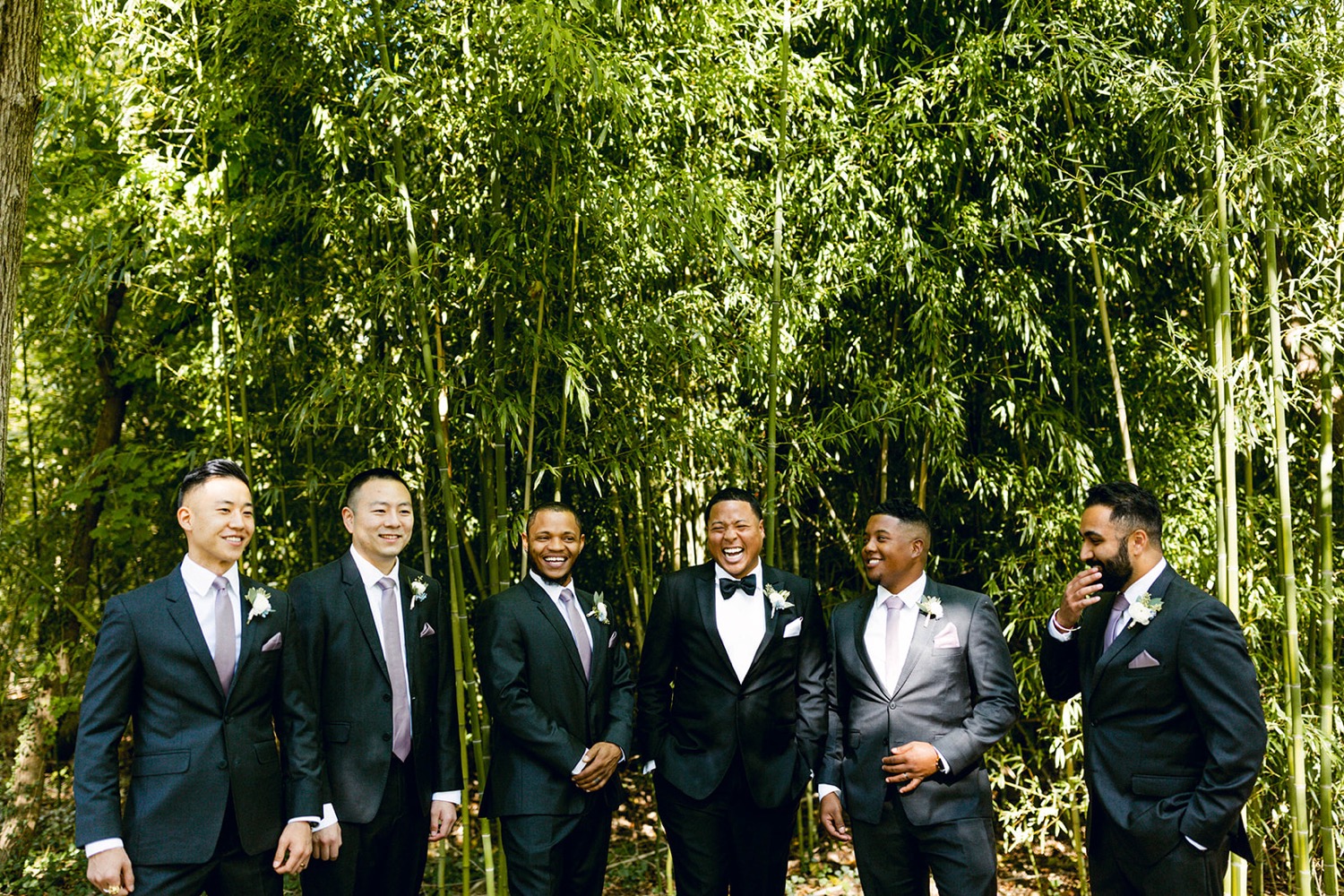 groom and groomsmen laughing wedding party candid