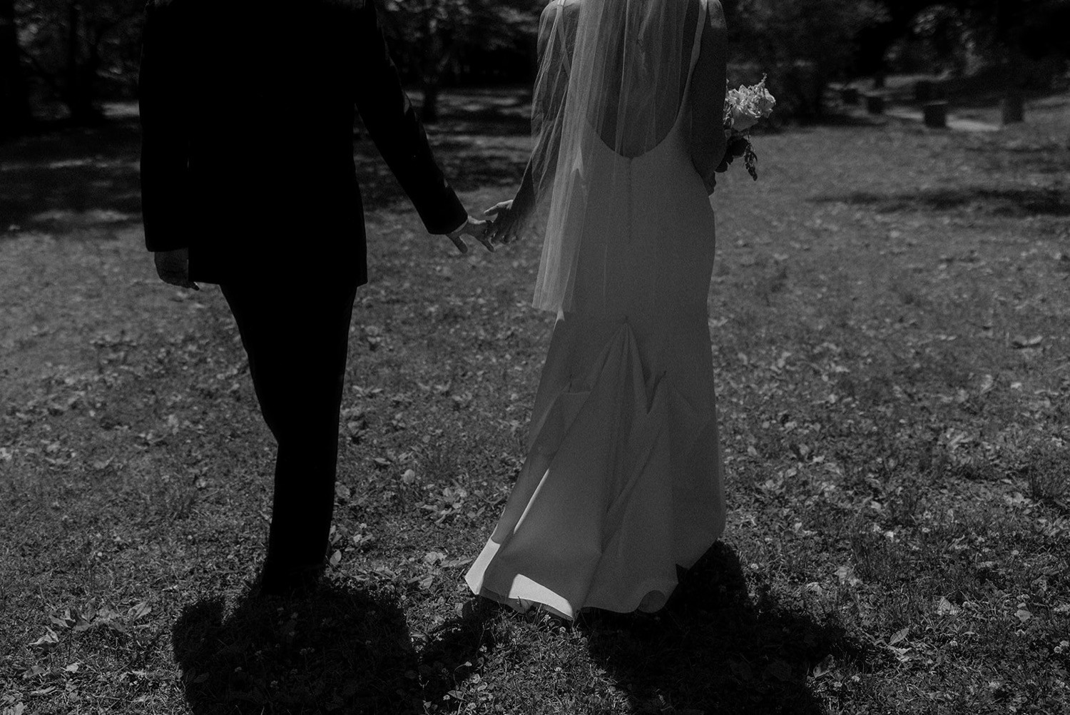 bride and groom holding hands walking away