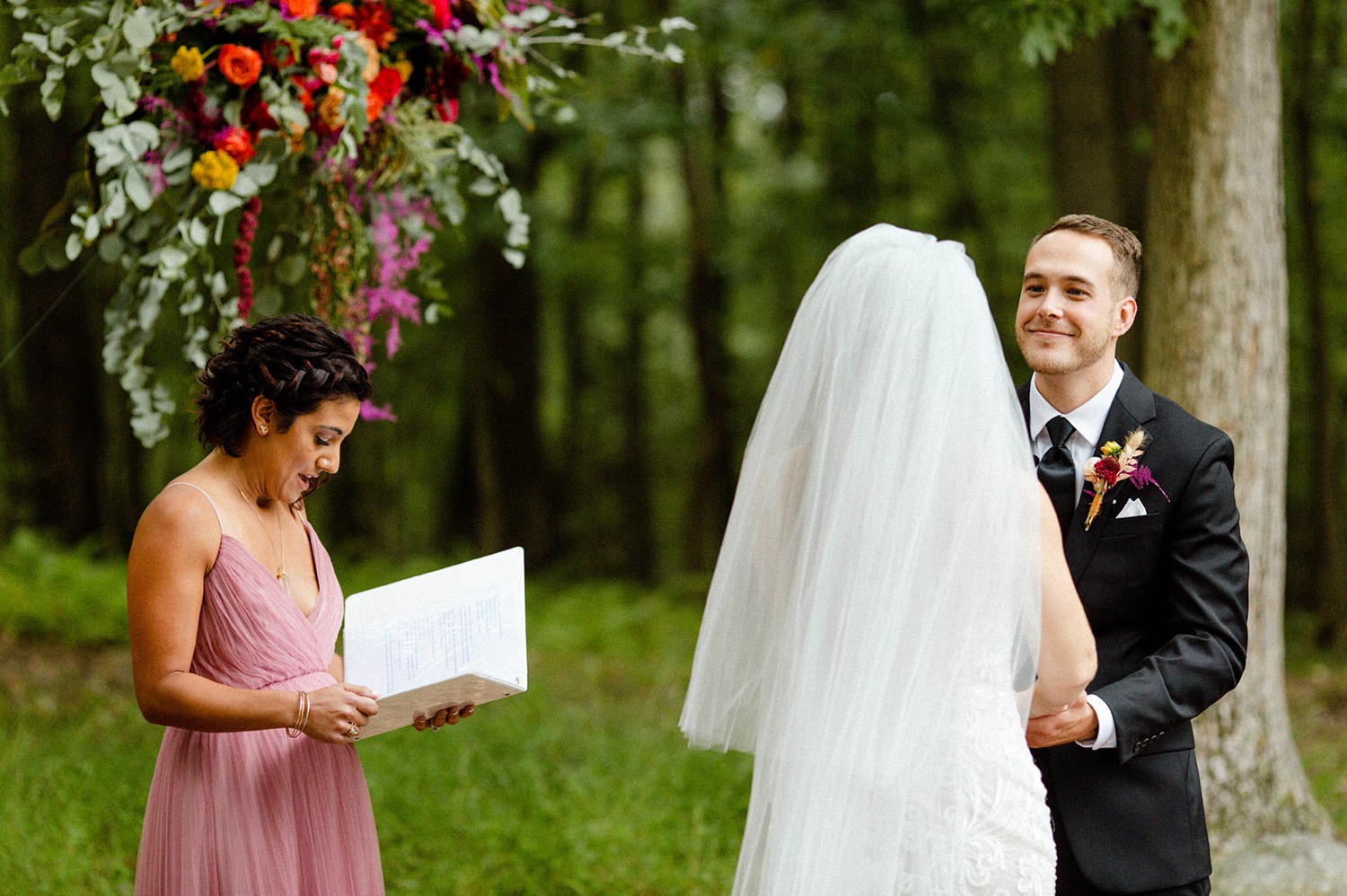 groom smiling at bride during backyard wedding ceremony