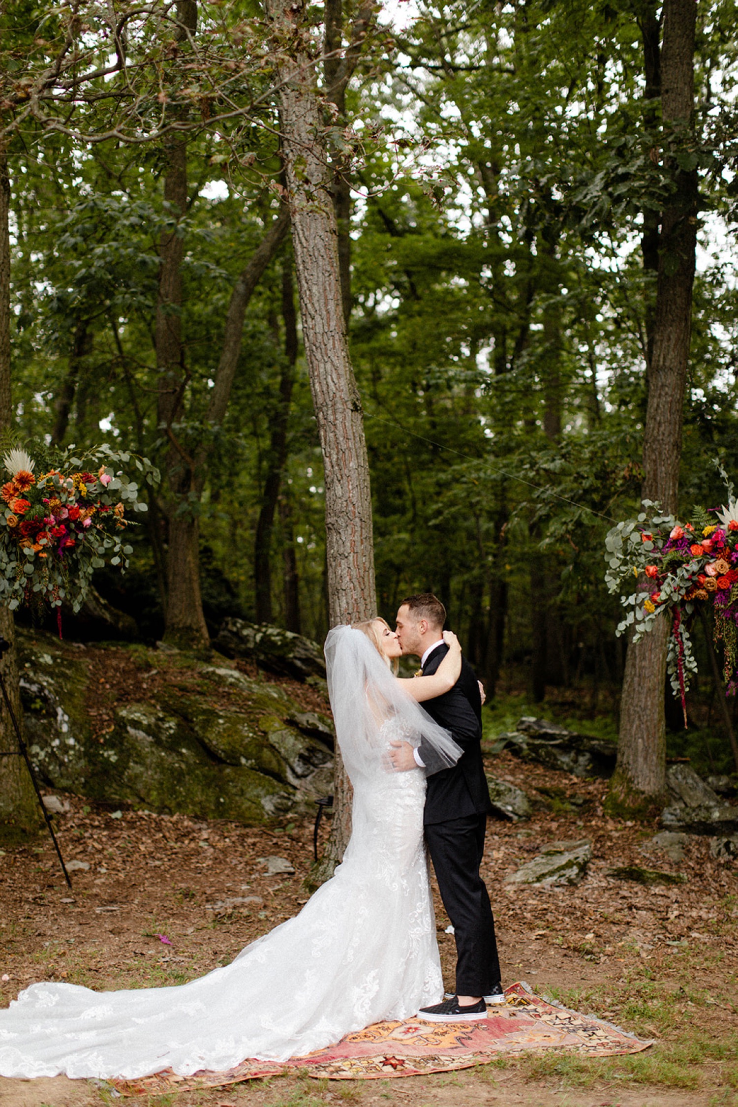 bride and groom kissing during backyard micro wedding ceremony
