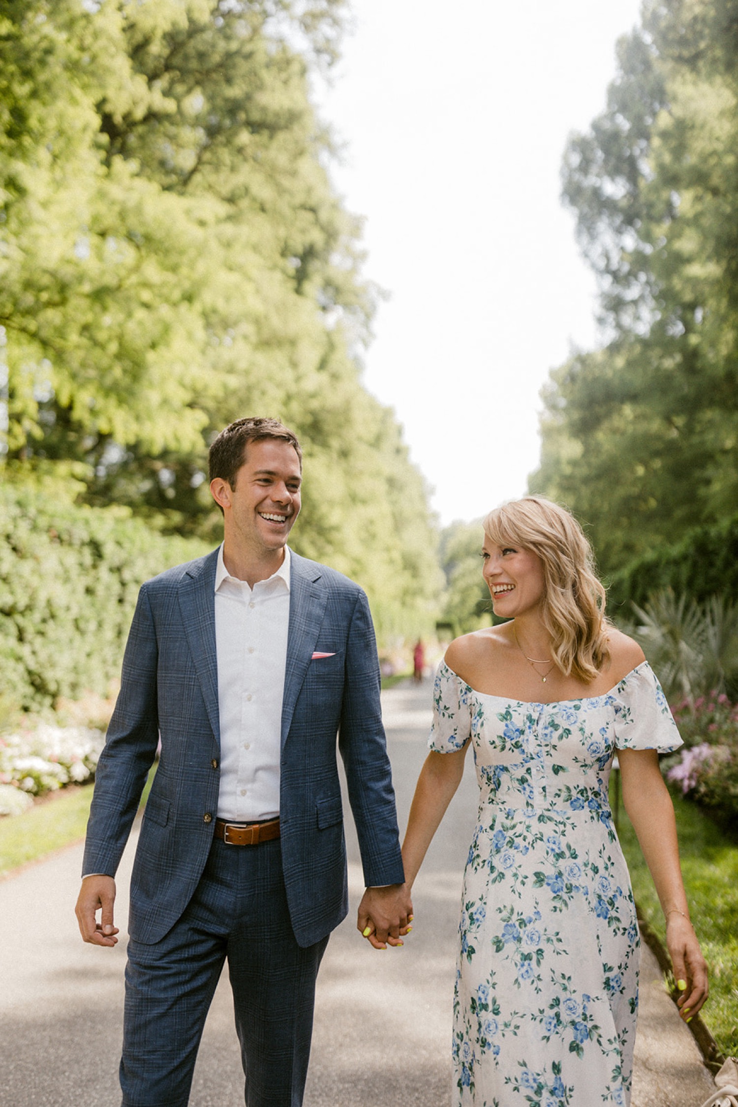longwood gardens engagement session couple walking on path in park