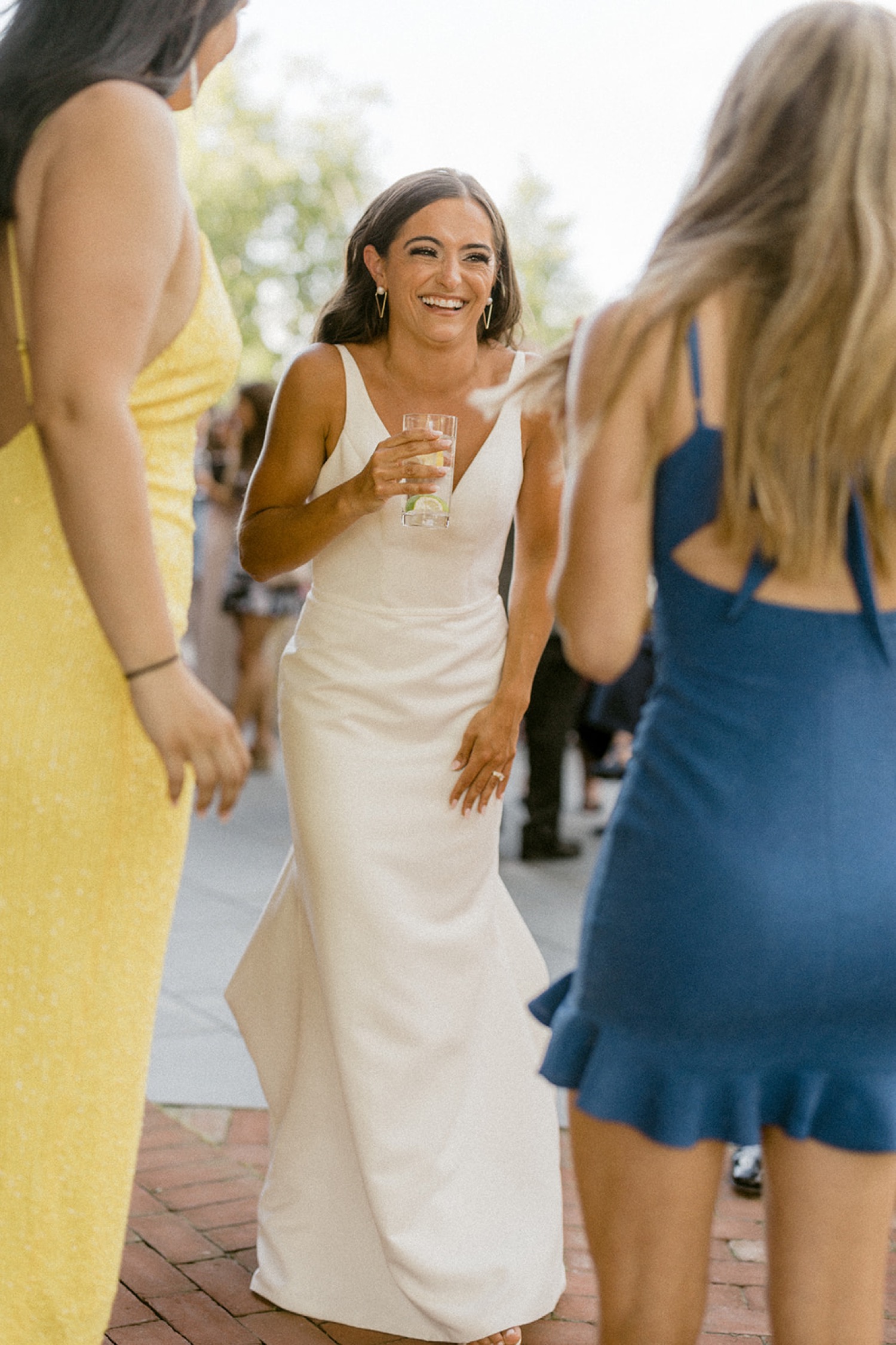 bride laughing with guests cocktail hour