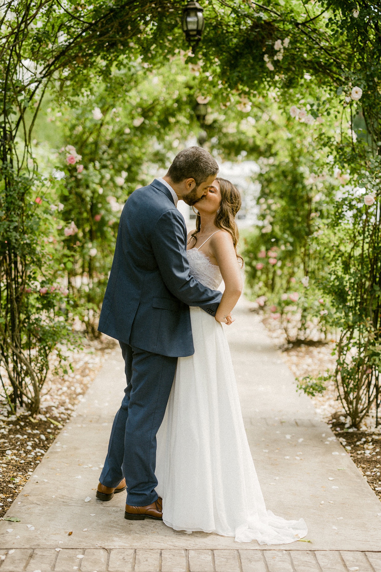 couple first kiss under rose arches moonstone manor wedding session