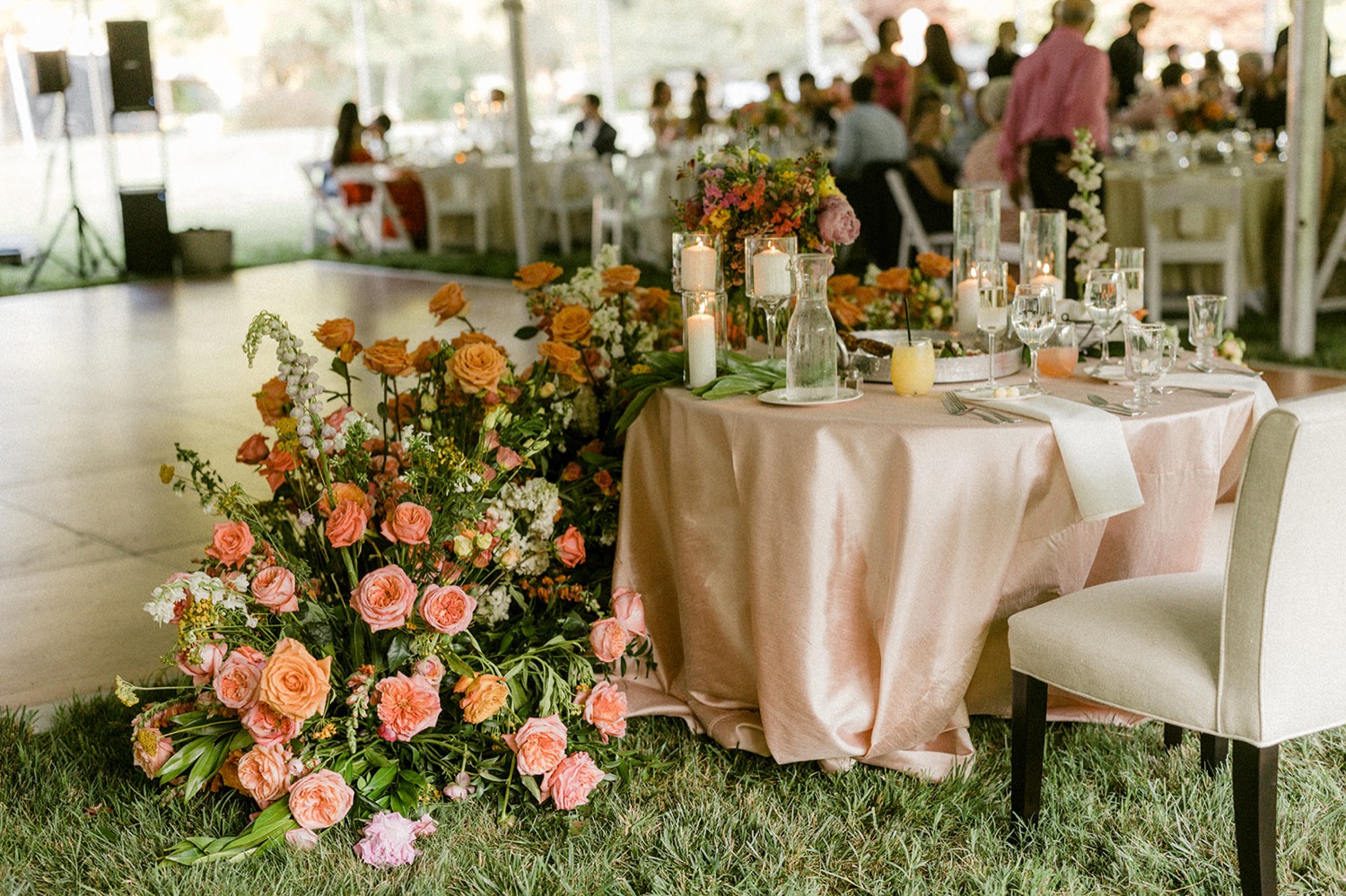 head table white chairs pink linen colorful floral arrangement