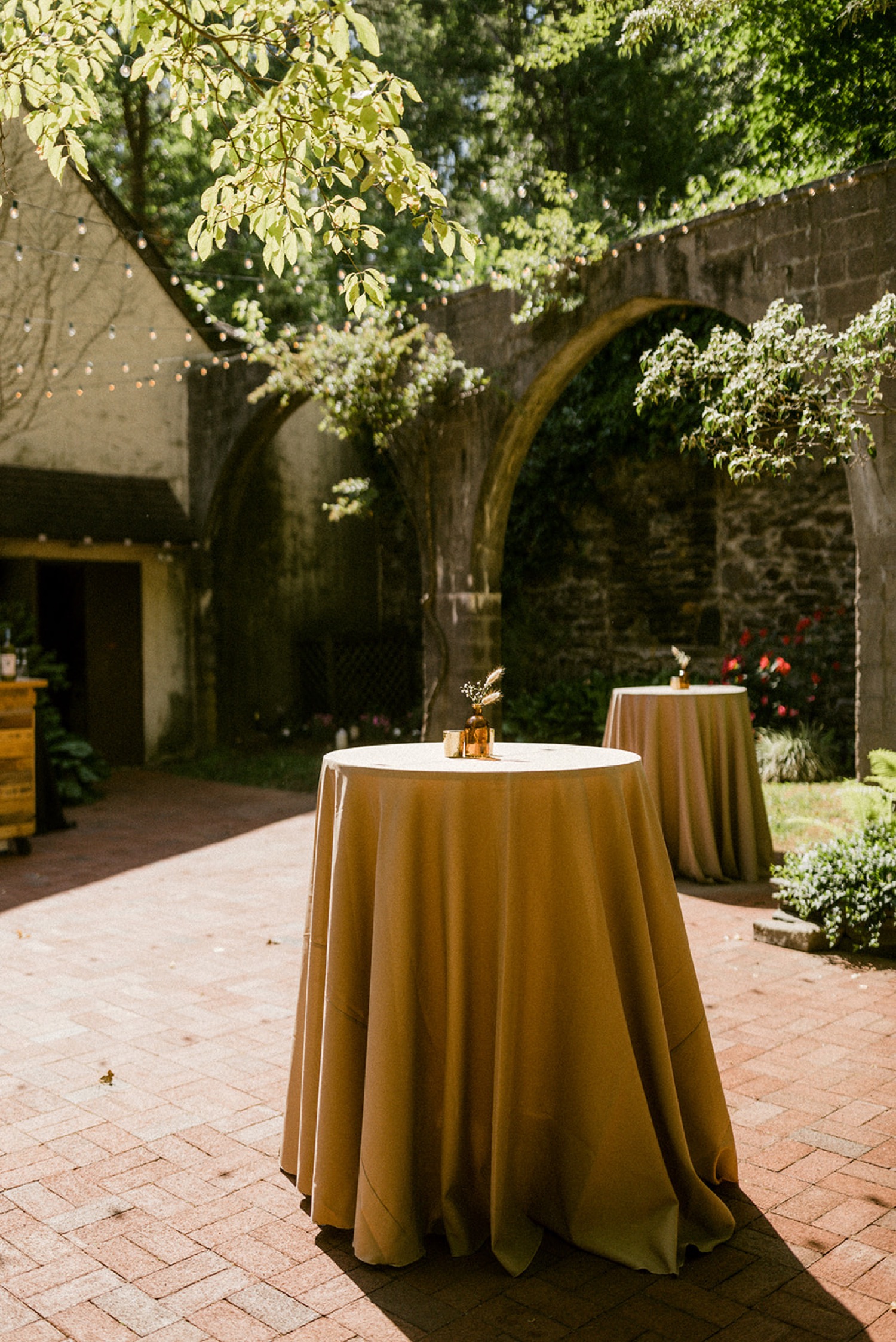simple tables champagne table cloths cocktail hour outside wedding courtyard the old mill philadelphia