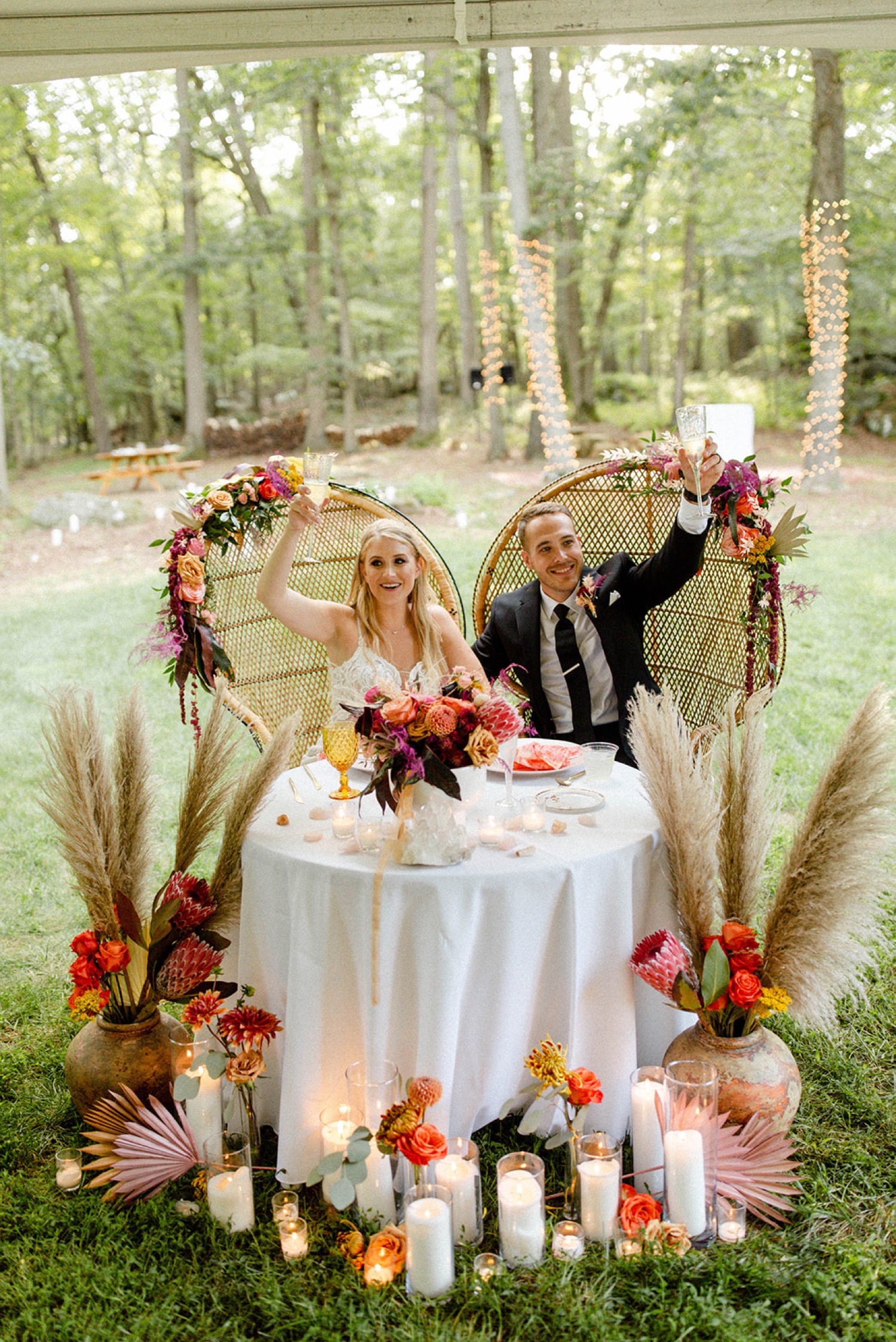 couple raising glasses toast colorful bohemian backyard wedding