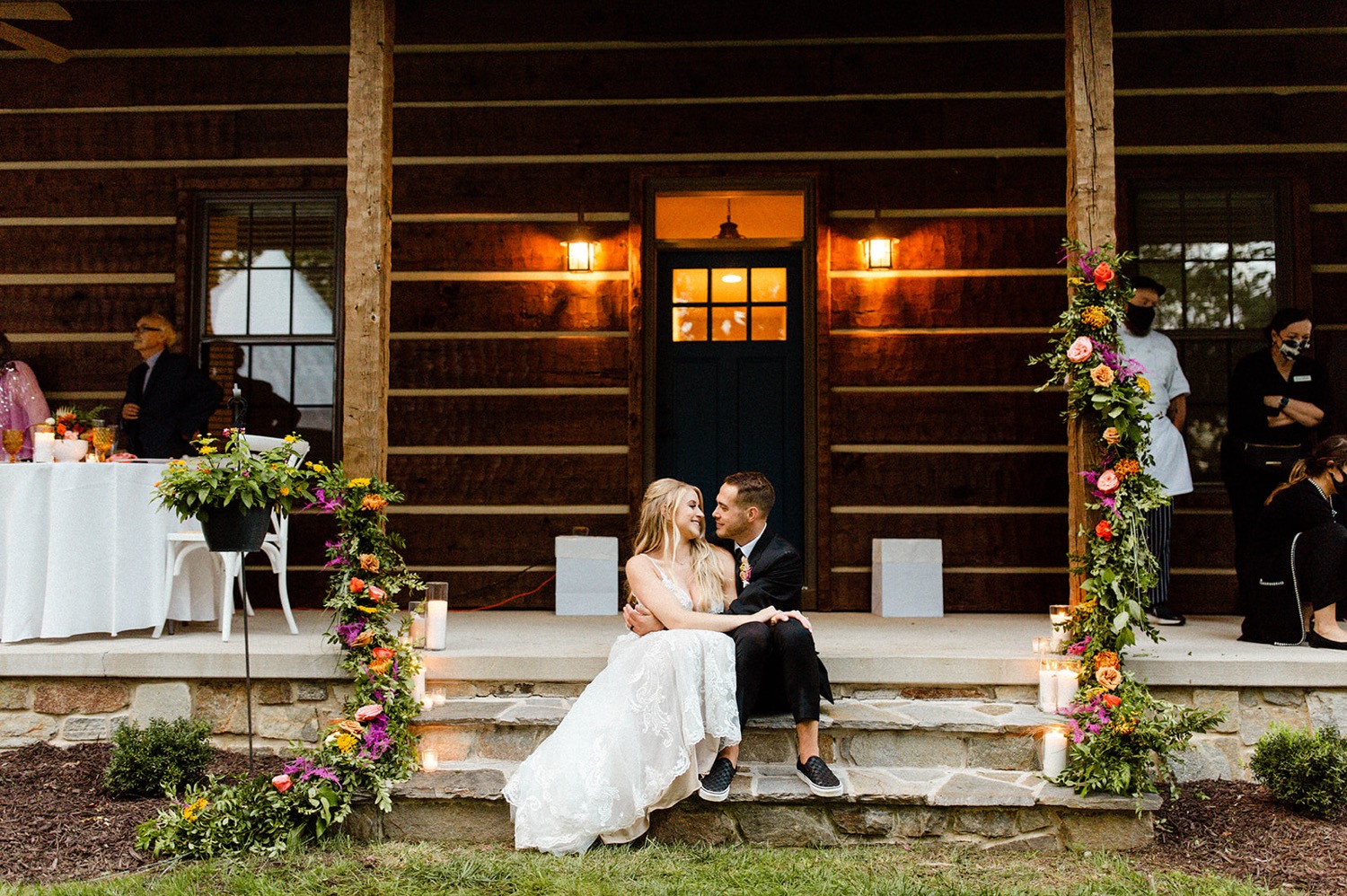 bride and groom sitting on cabin steps colorful bohemian backyard wedding