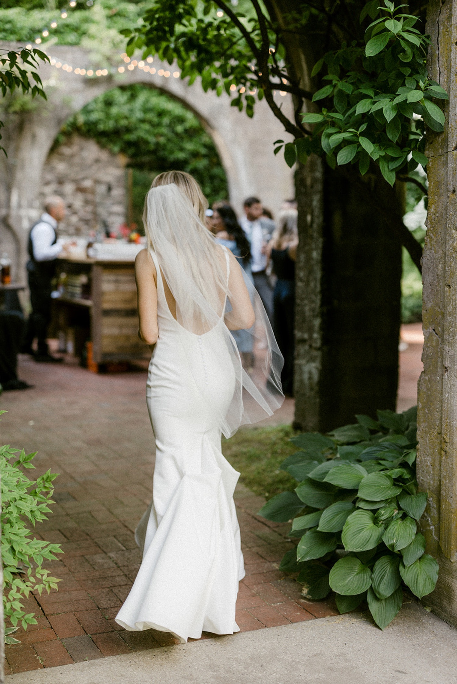 bride walking into cocktail hour outside courtyard the old mill philadelphia