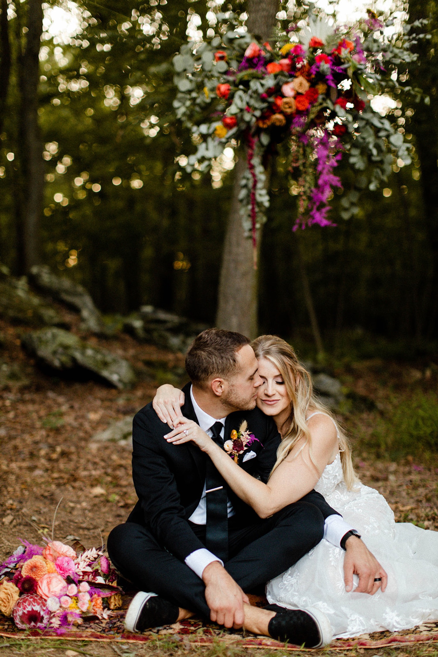 bride and groom sitting in forest couples portraits colorful bohemian backyard wedding