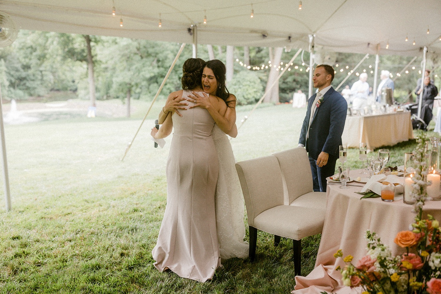 bride hugging bridesmaid crying after wedding toast speech