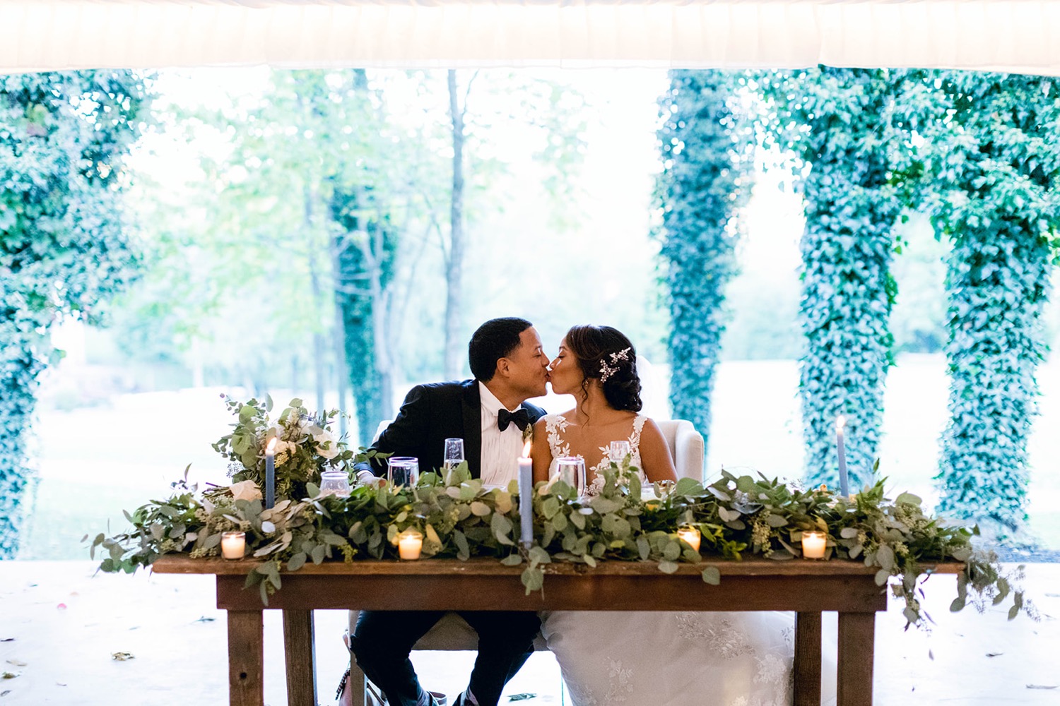 bride and groom kissing at head table fairytale wedding at historic shady lane
