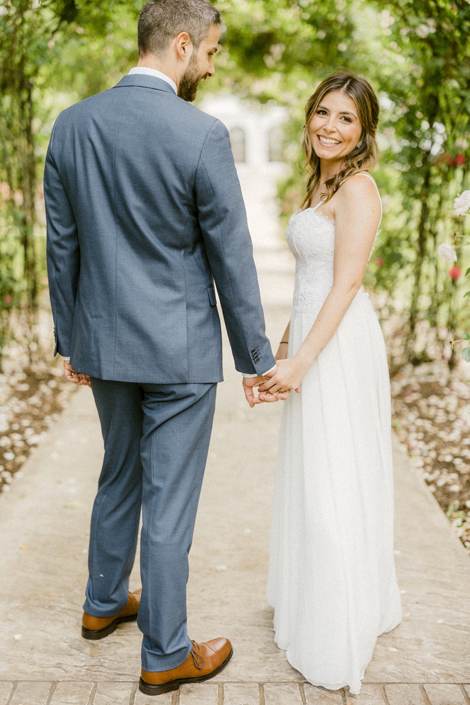 couple holding hands looking over shoulder wedding session